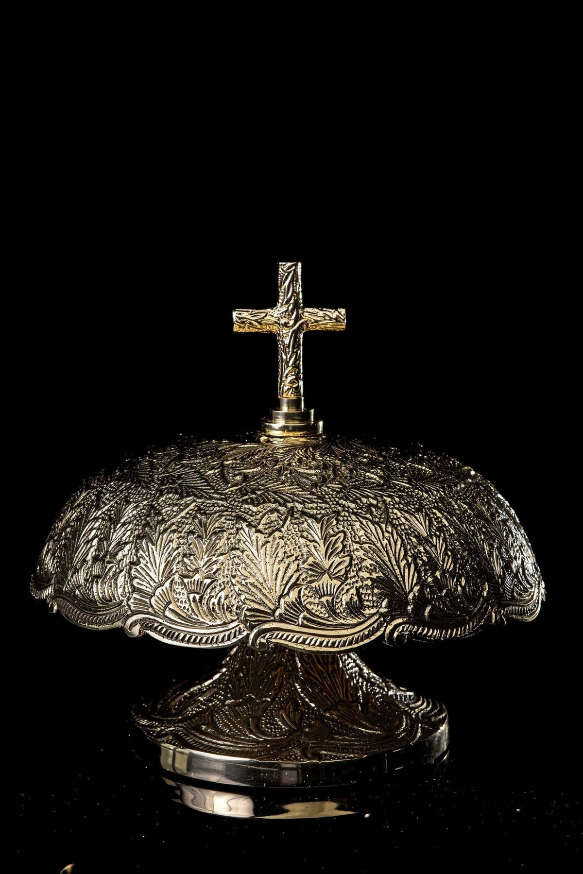 Brass altar bells, full front view with ornate leaf motifs and cross