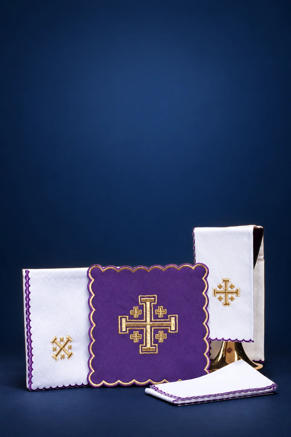 Purple altar linen set with scalloped edges and Jerusalem cross embroidery, shown with folded cloths and purificator