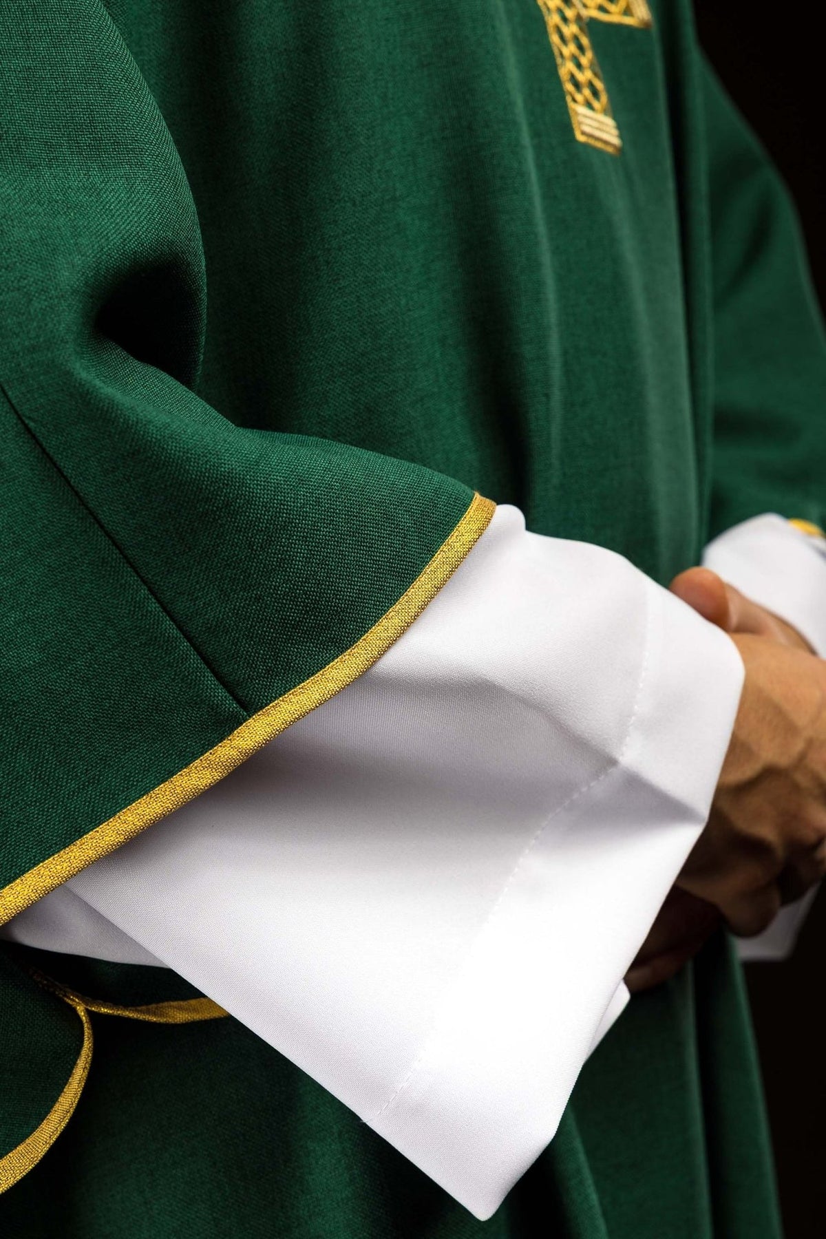 Green dalmatic close-up of gold-trimmed sleeve over white cuff