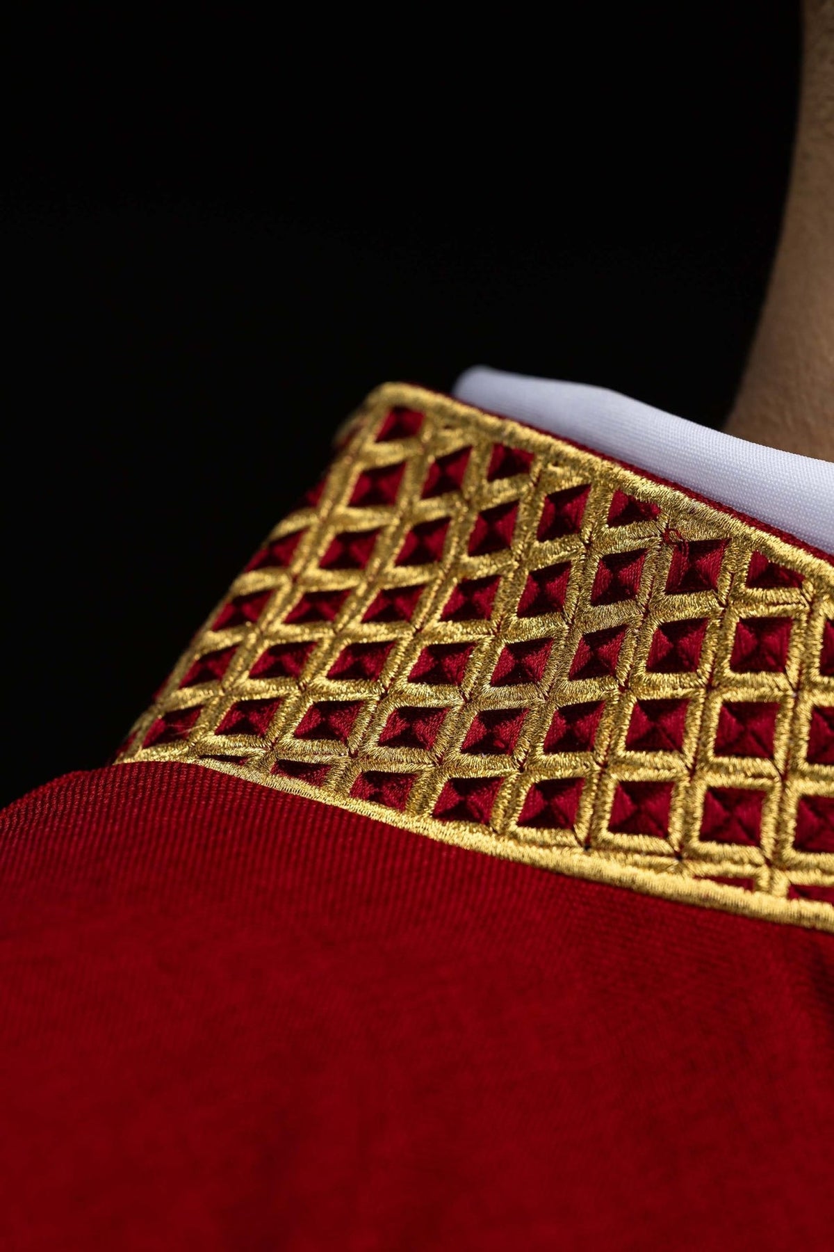 Red dalmatic collar detail with gold embroidered lattice