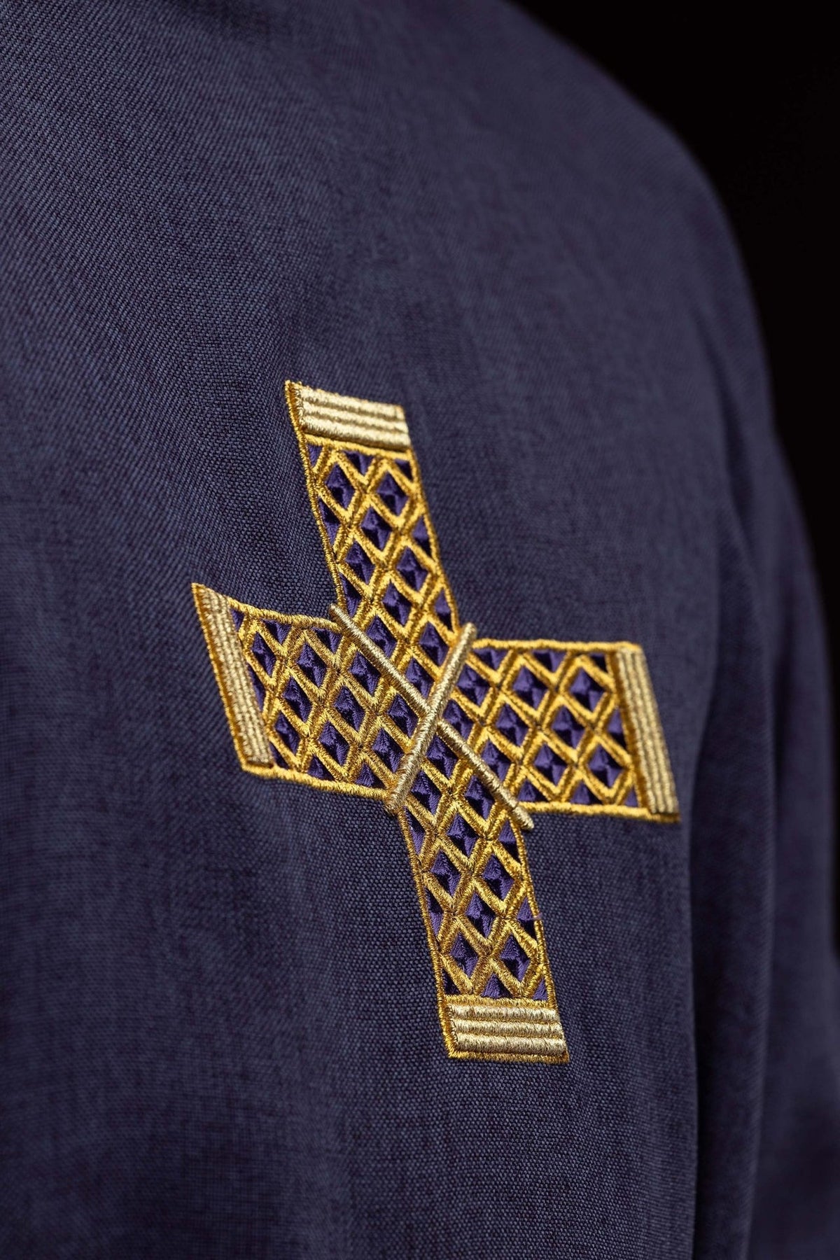Purple dalmatic front embroidery close-up showing gold cross