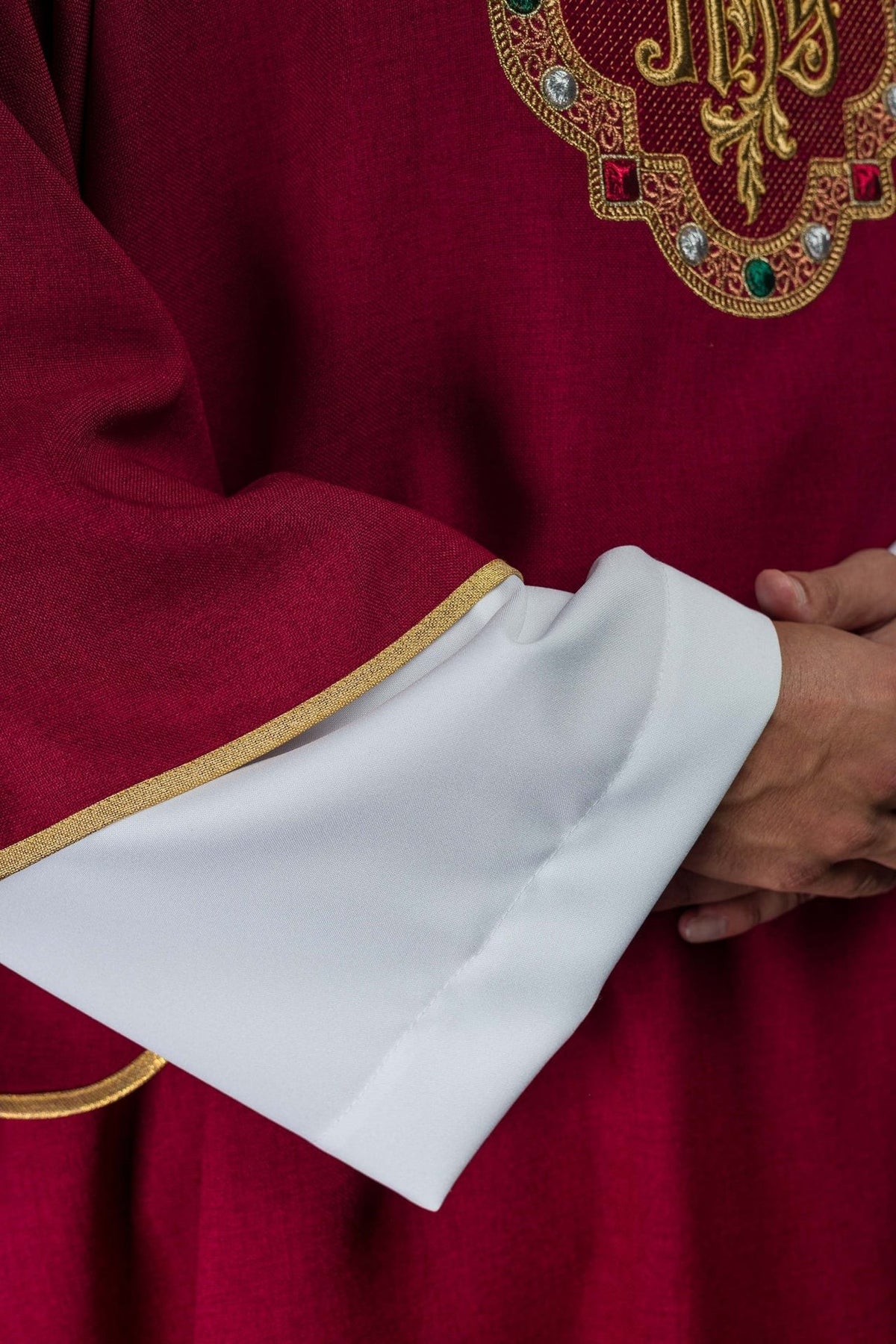Red dalmatic close-up of sleeve with gold trim and white lining