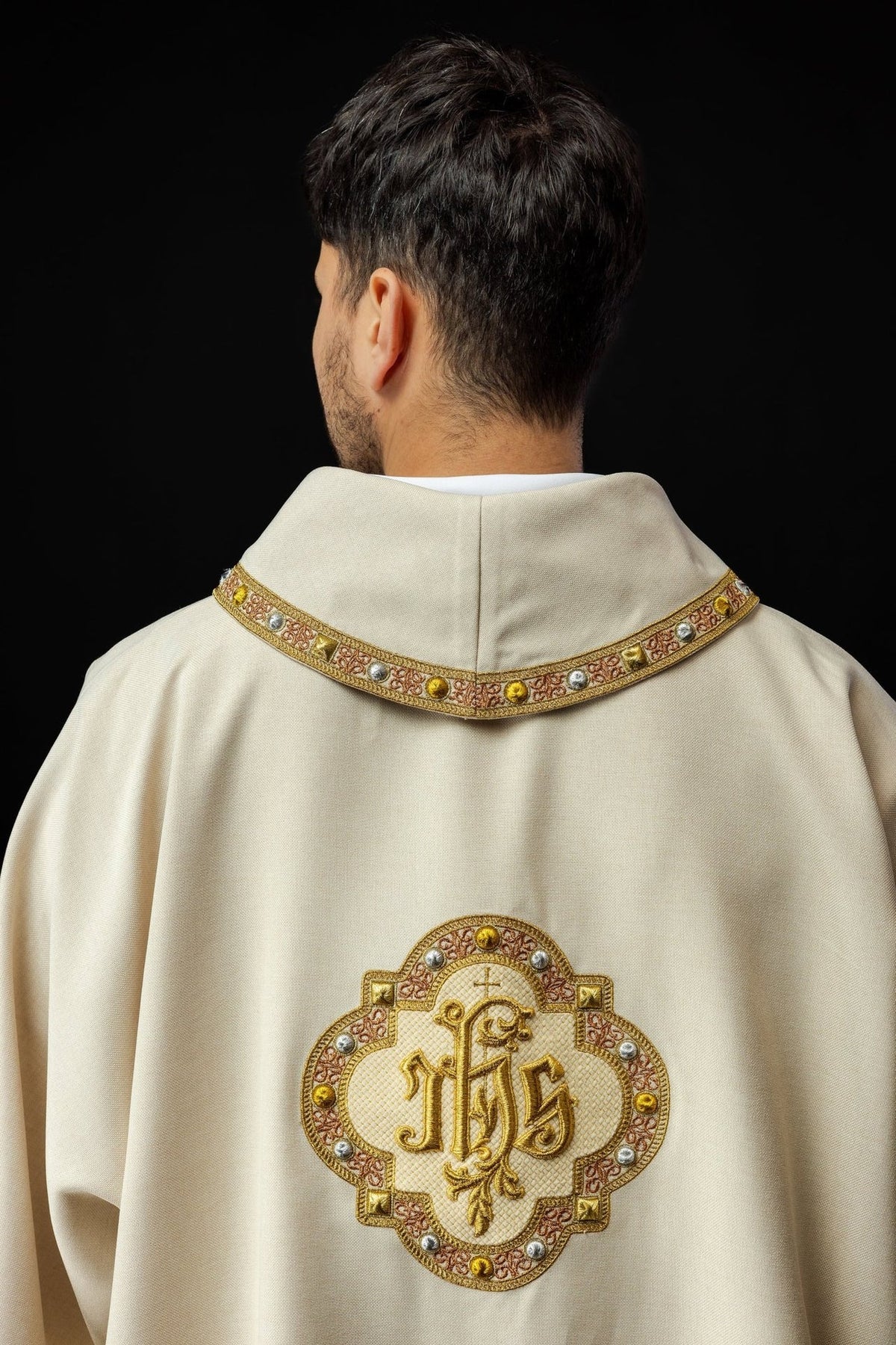 Ecru dalmatic back view with embroidered IHS symbol and decorated collar trim
