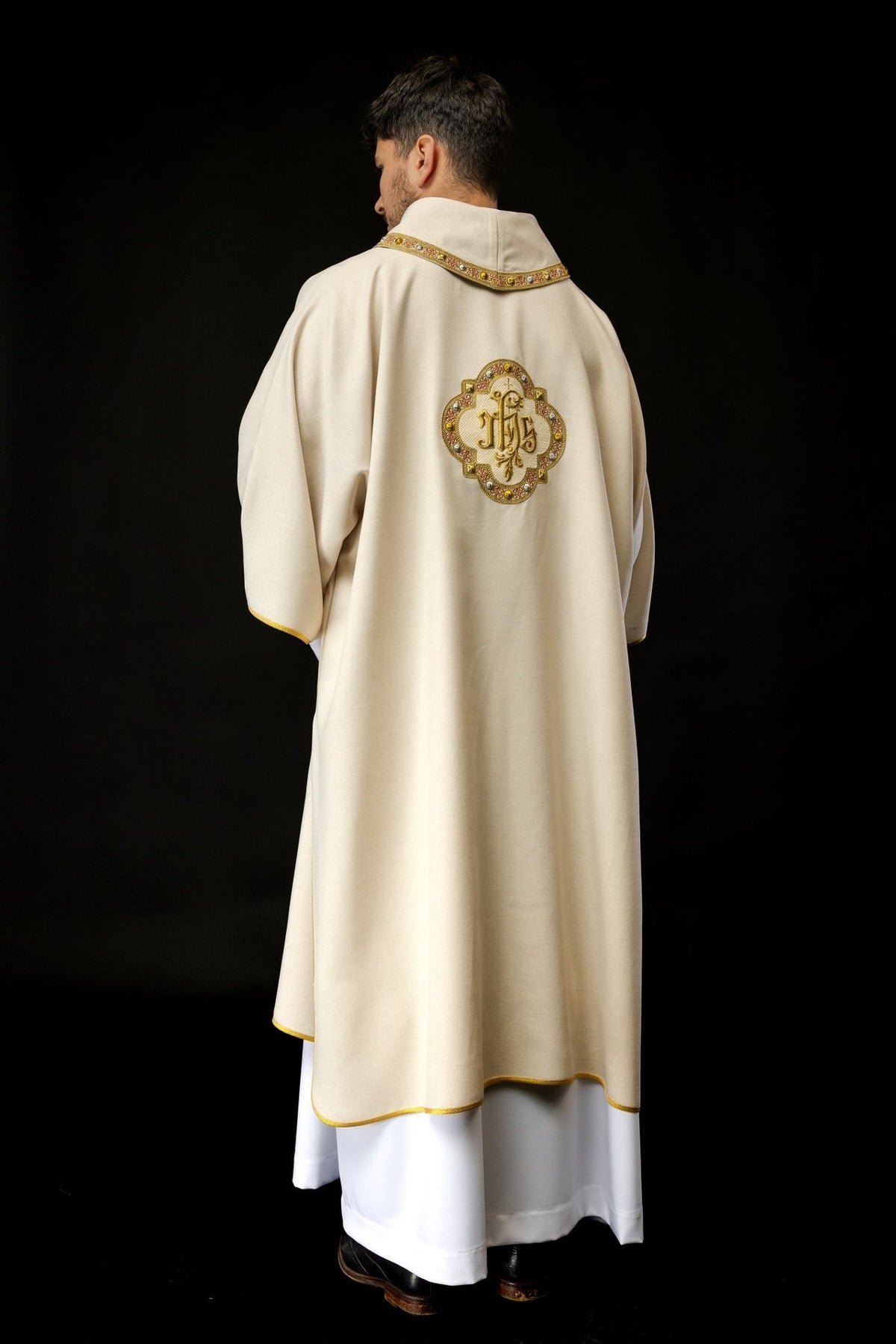Ecru dalmatic back view showing full length, embroidered IHS symbol and gold trim