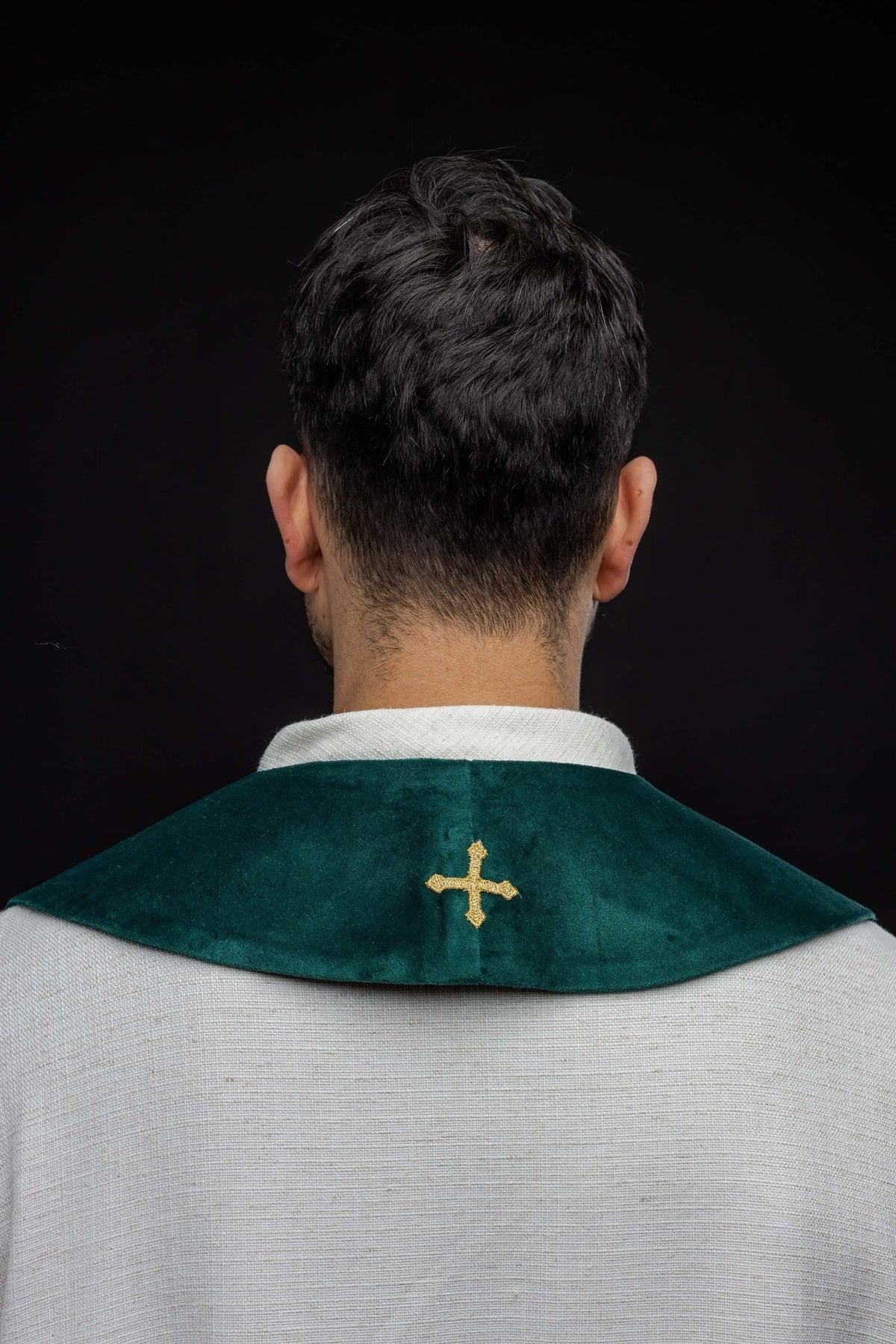 Green stole worn from the back, showing a small gold embroidered cross