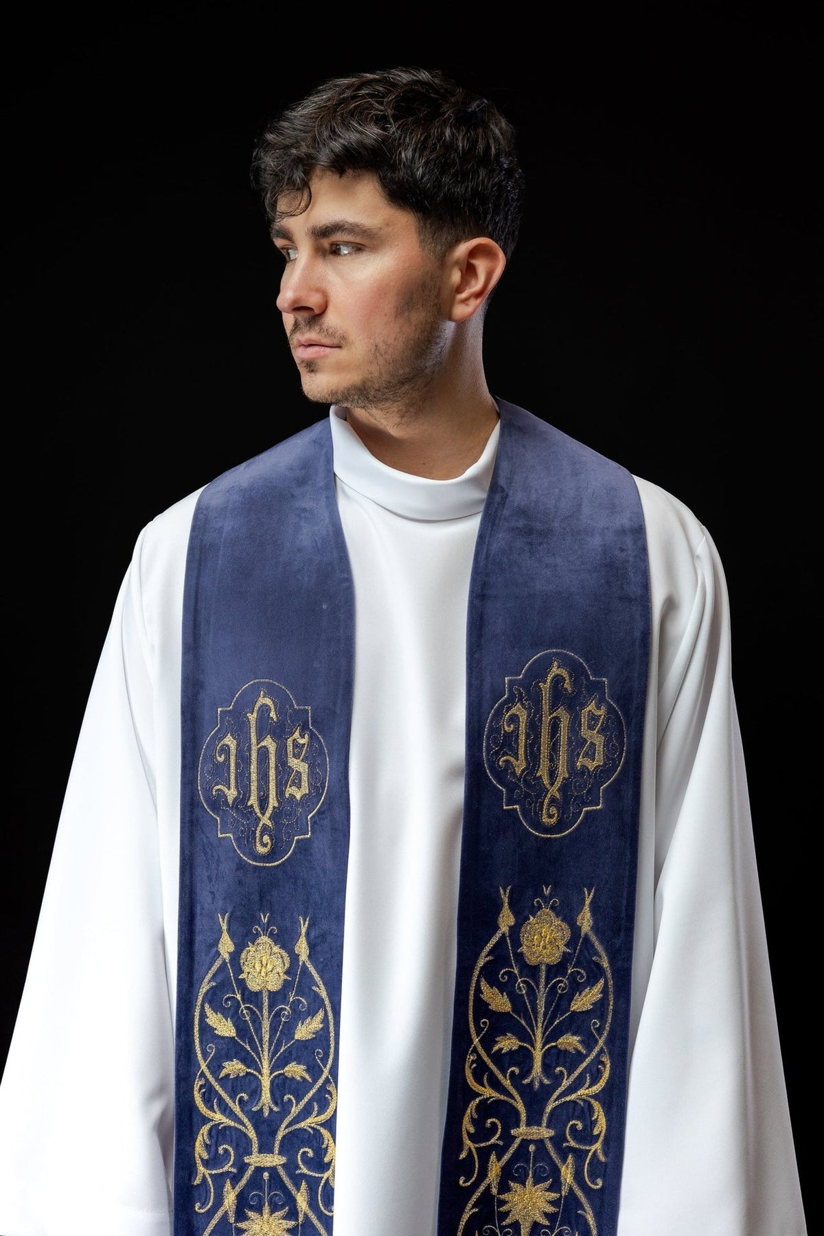 Purple stole close-up showing embroidered gold IHS motifs and floral embroidery
