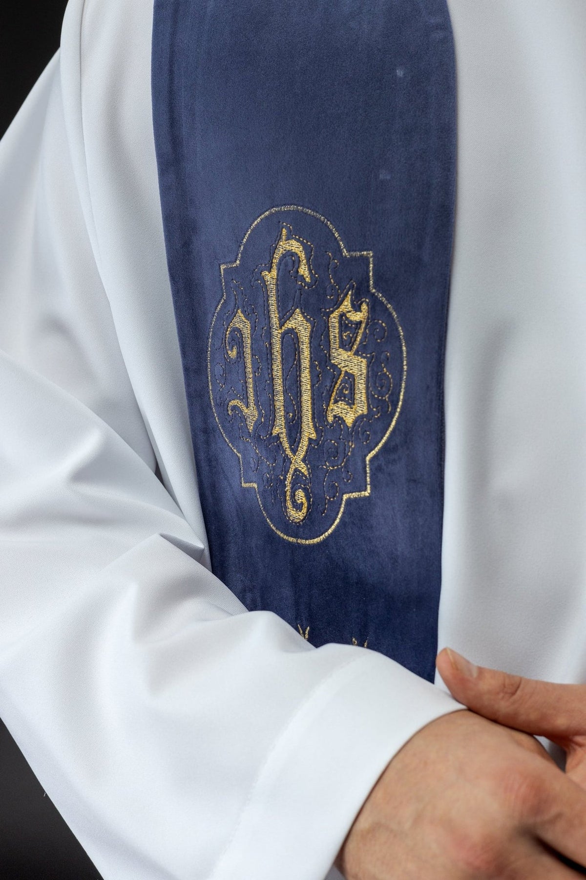 Purple stole detail showing embroidered gold IHS emblem