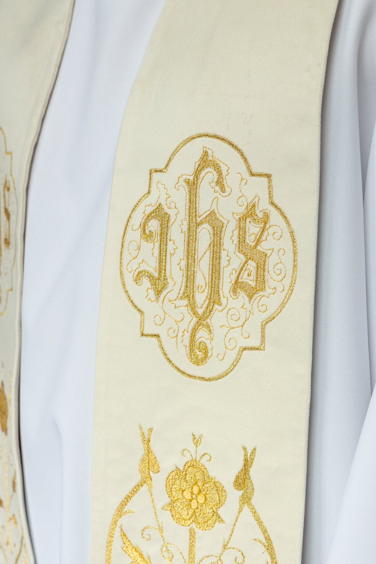 IHS stole close-up showing ornate gold embroidery on ecru fabric