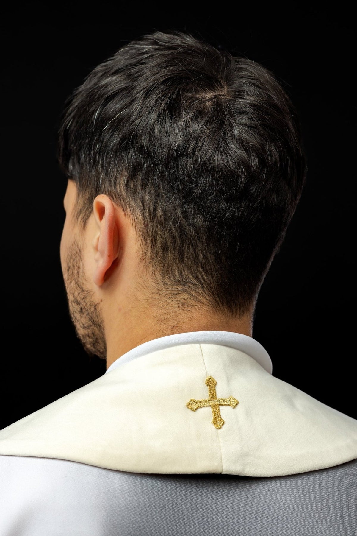 Ecru stole worn from the back with a small gold embroidered cross
