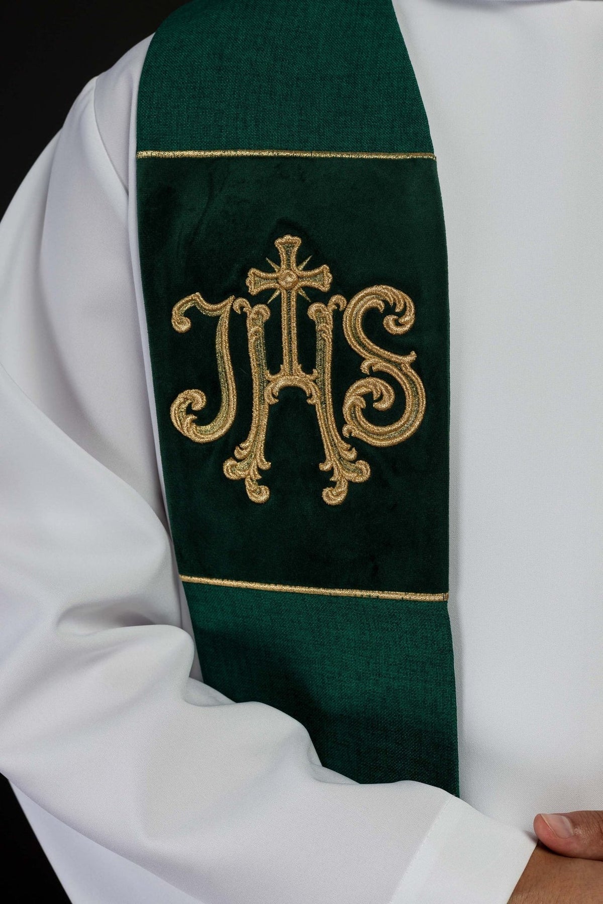 Green velvet stole close-up showing embroidered gold IHS motif and trim