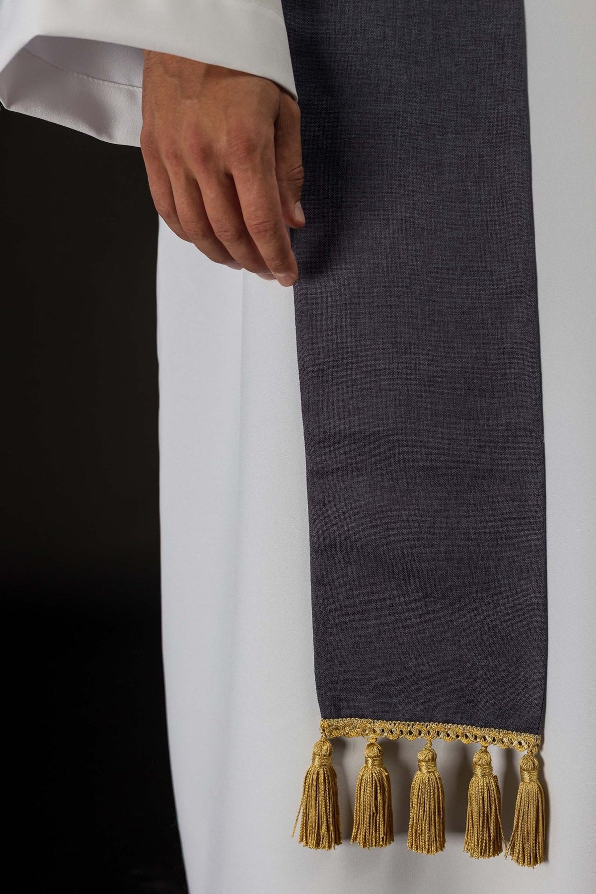 Purple stole detail showing plain polyester fabric and gold tassel fringe