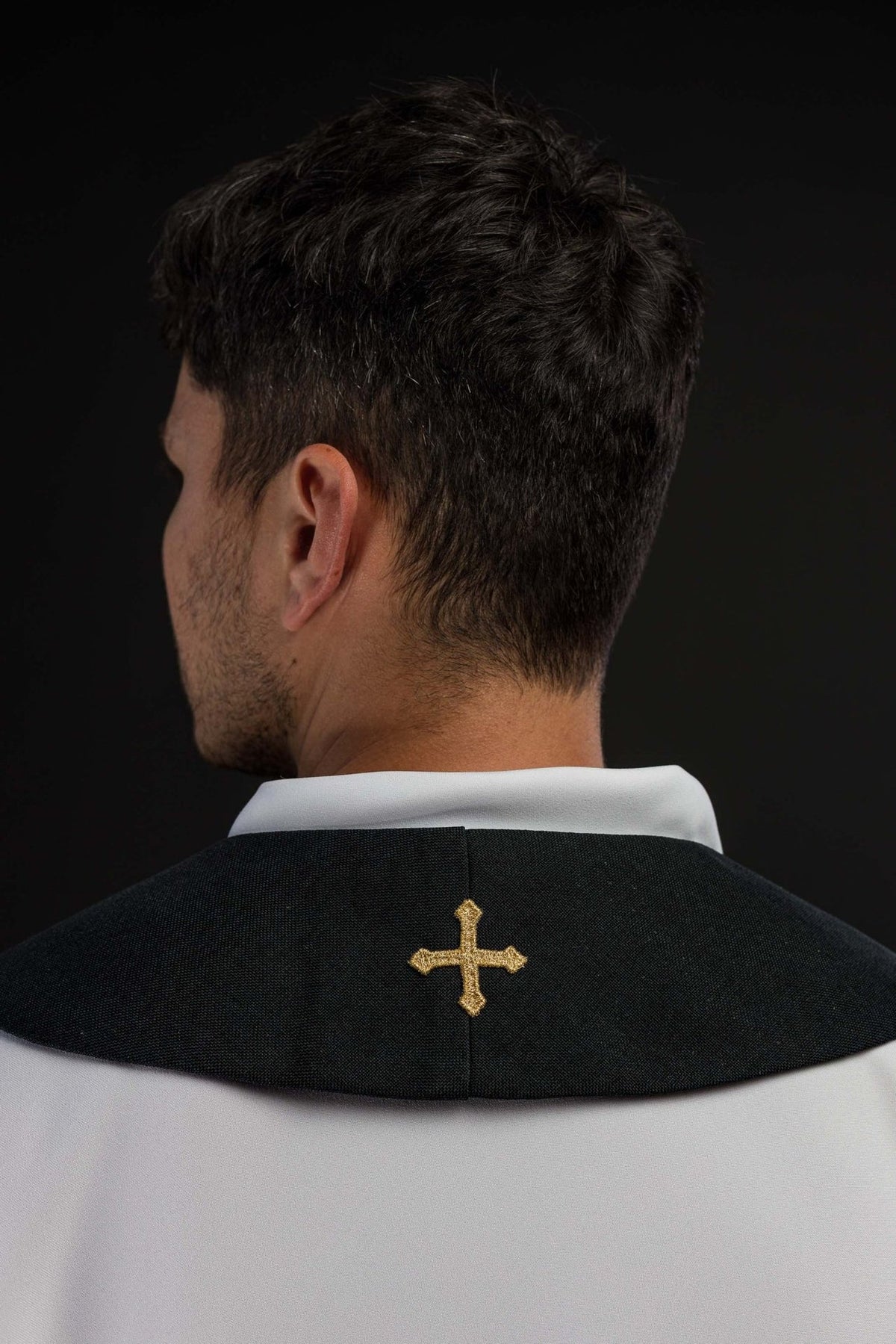 Black stole worn back view with a small gold embroidered cross