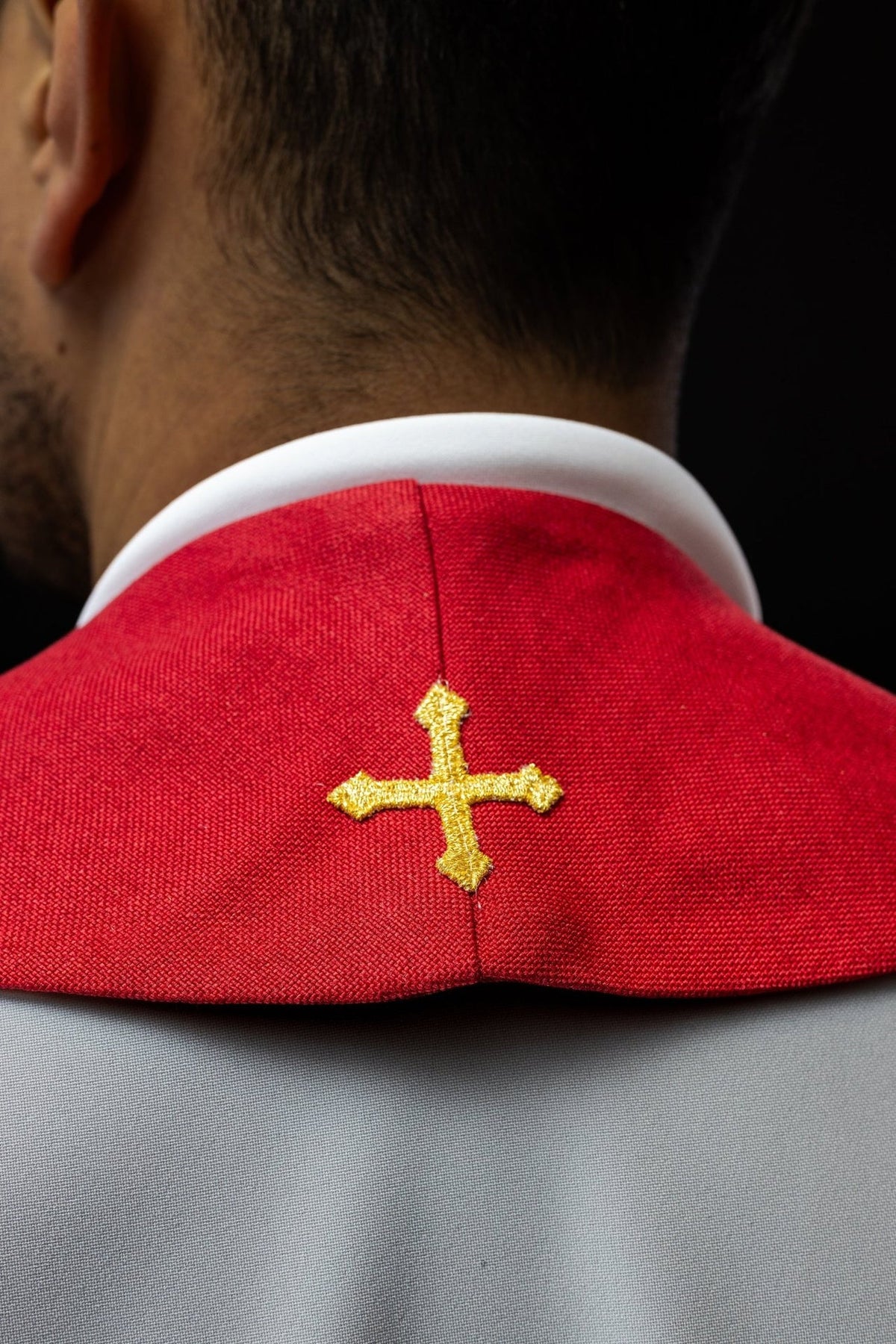 Red embroidered stole back close-up with a single gold cross