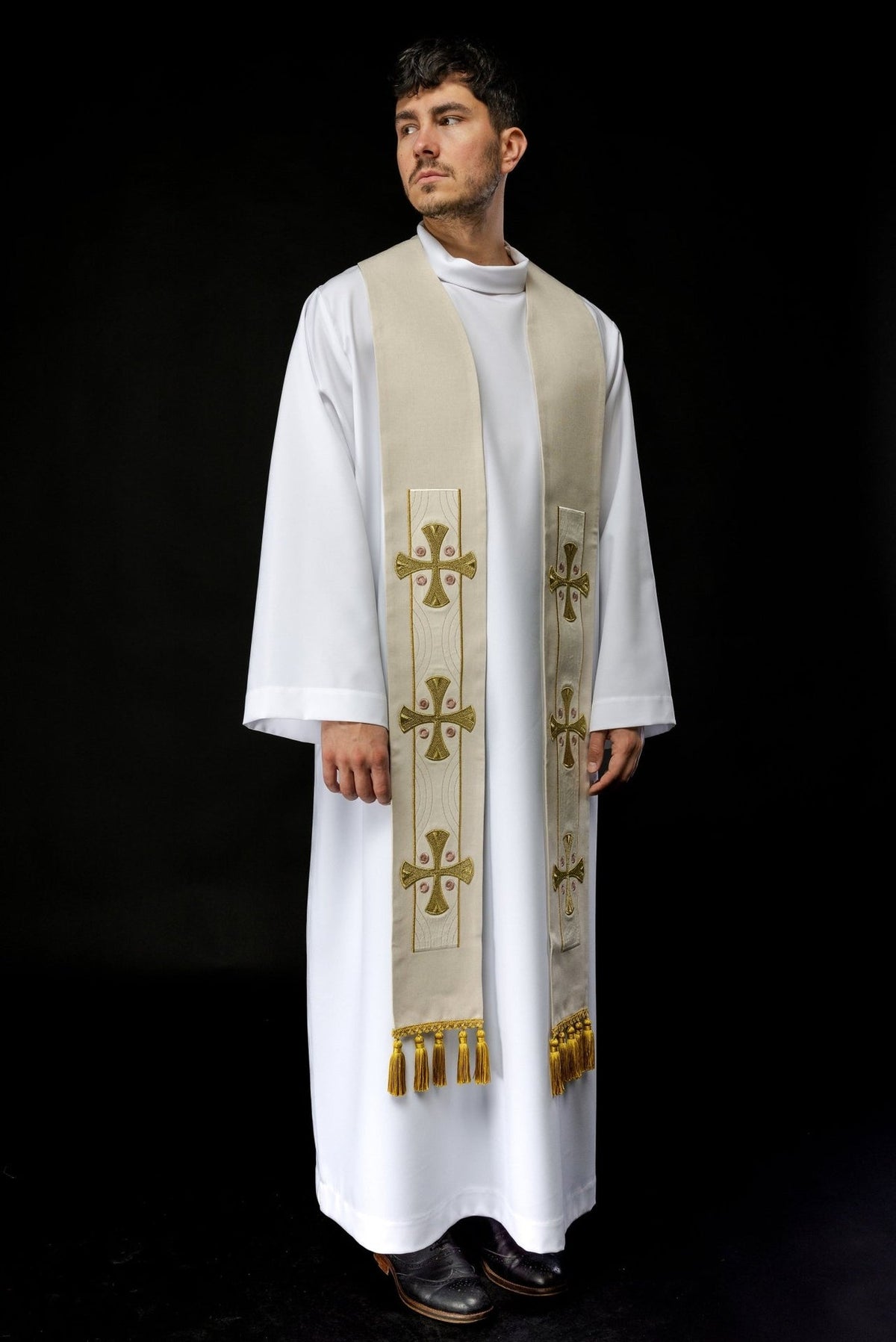 Embroidered ecru stole worn front, showing repeated crosses and gold tassels