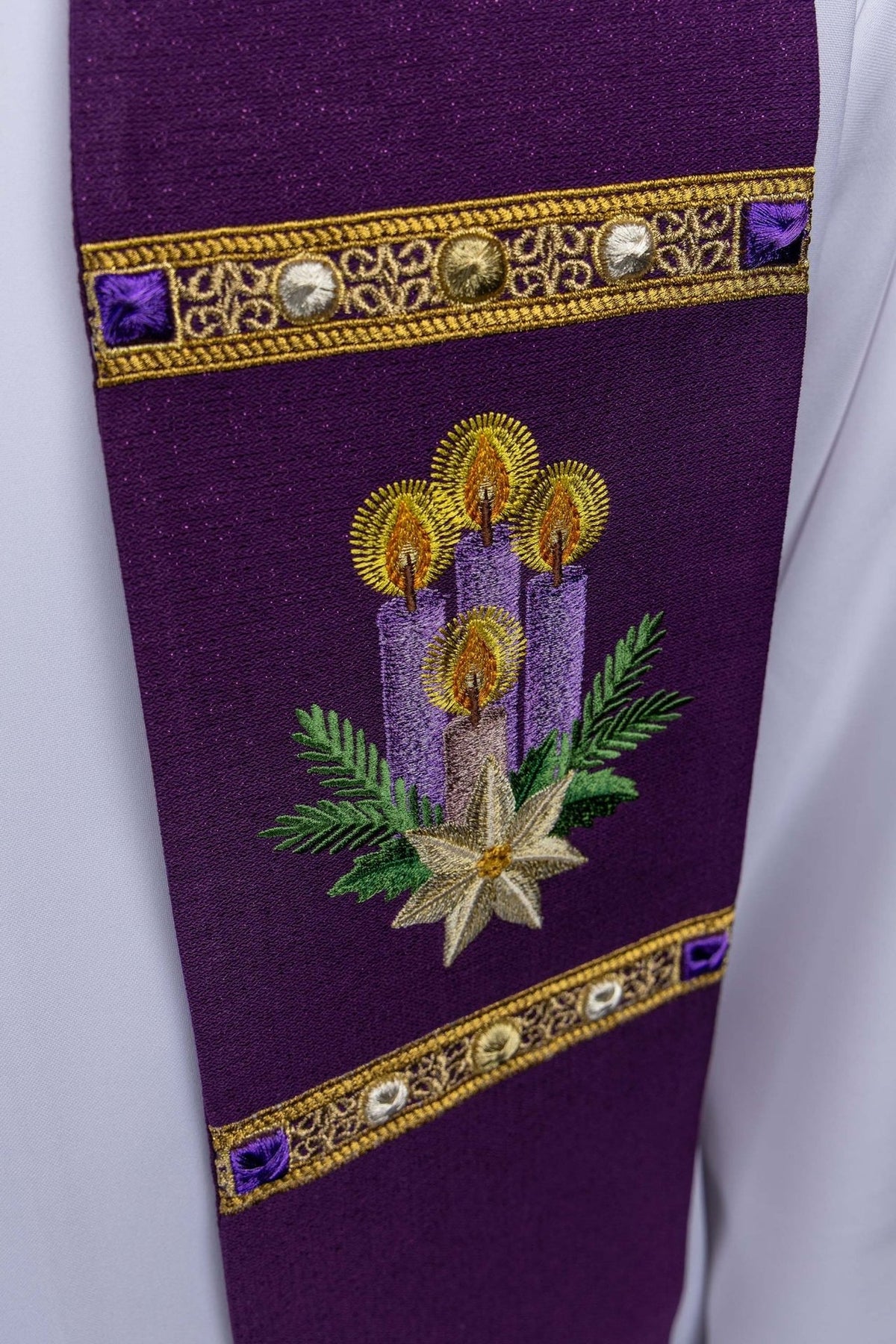 Purple stole close-up with embroidered Advent candles, greenery and gold star