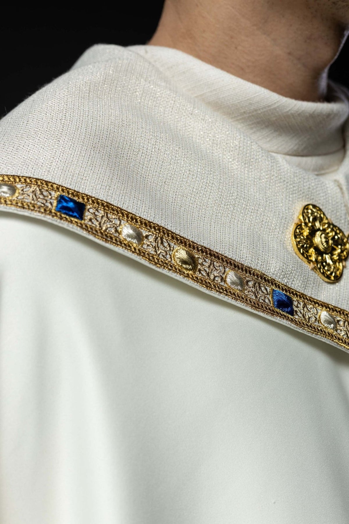 Embroidered cope close-up showing ecru jacquard fabric and gold trim