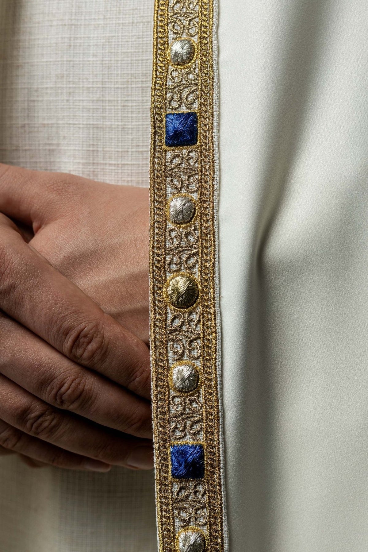 Embroidered cope trim close-up with gold and blue embroidered details