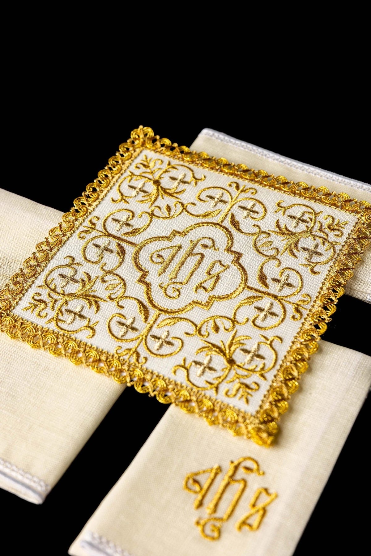 Altar linen set close-up showing gold JHS embroidery, ornate scrollwork and decorative trim