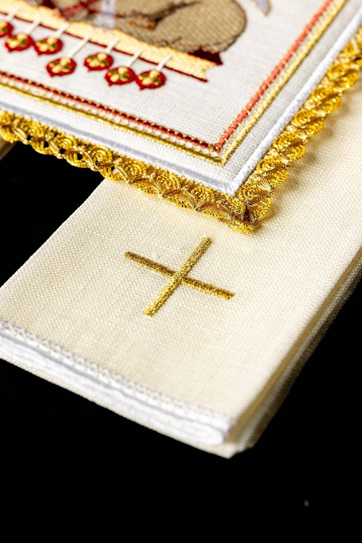 Altar linen set close-up showing white linen fabric, gold cross embroidery, and stitched edging