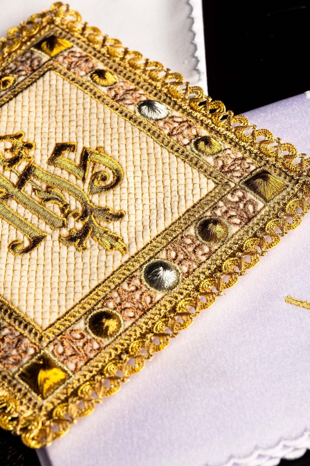 Altar linen set detail showing embroidered IHS symbol and gold decorative edging
