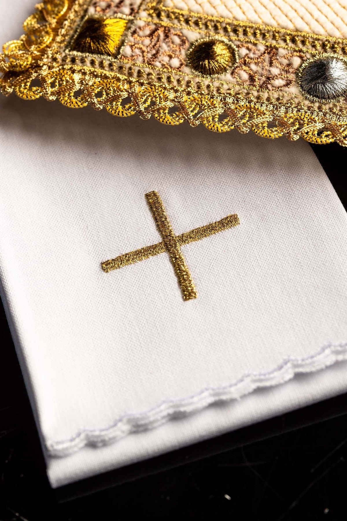 Altar linen set detail showing gold embroidered cross and scalloped edging