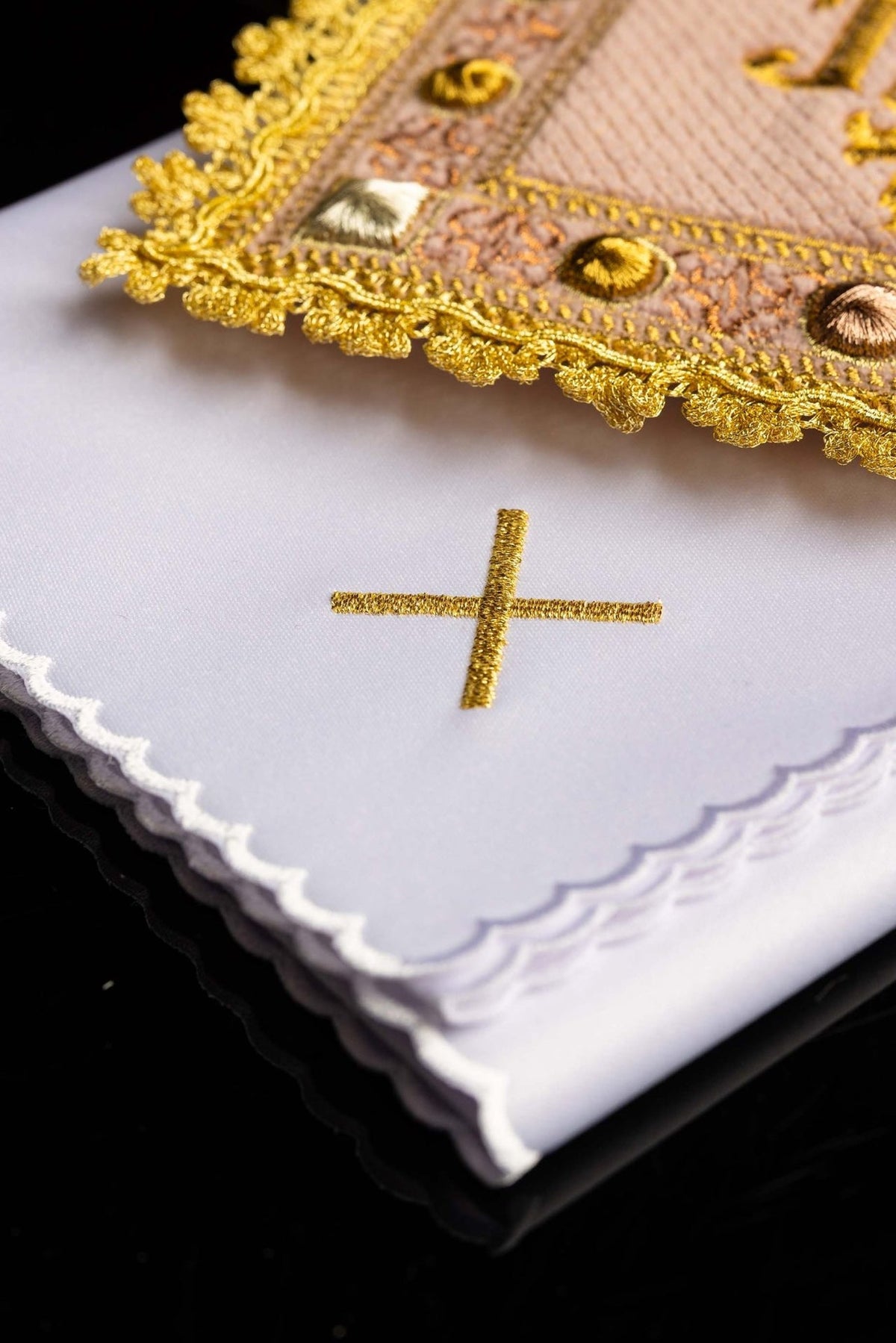 Altar linen set close-up showing gold embroidered cross and scalloped white edge