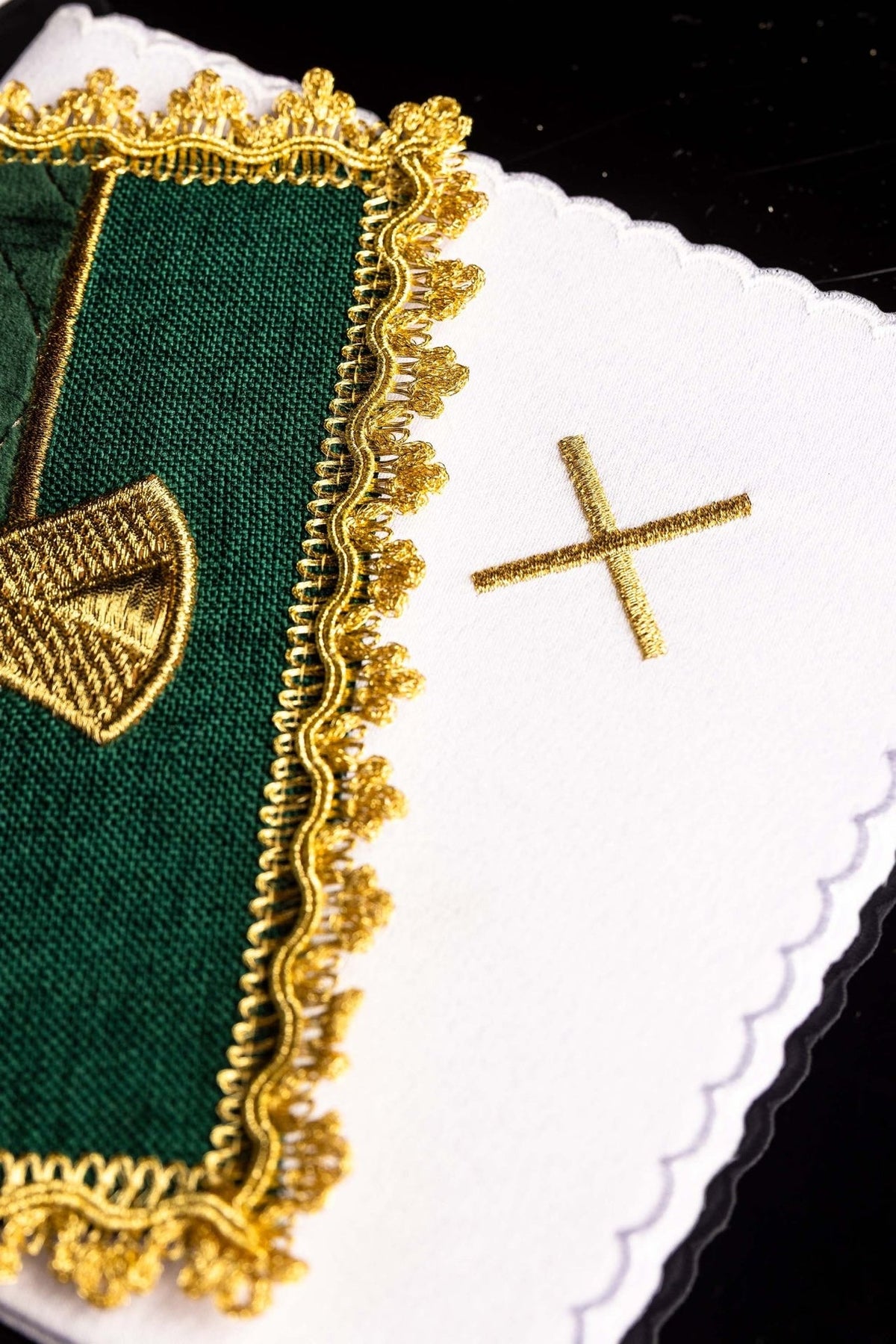 Altar linen set detail showing green velvet pall beside white linen with gold cross