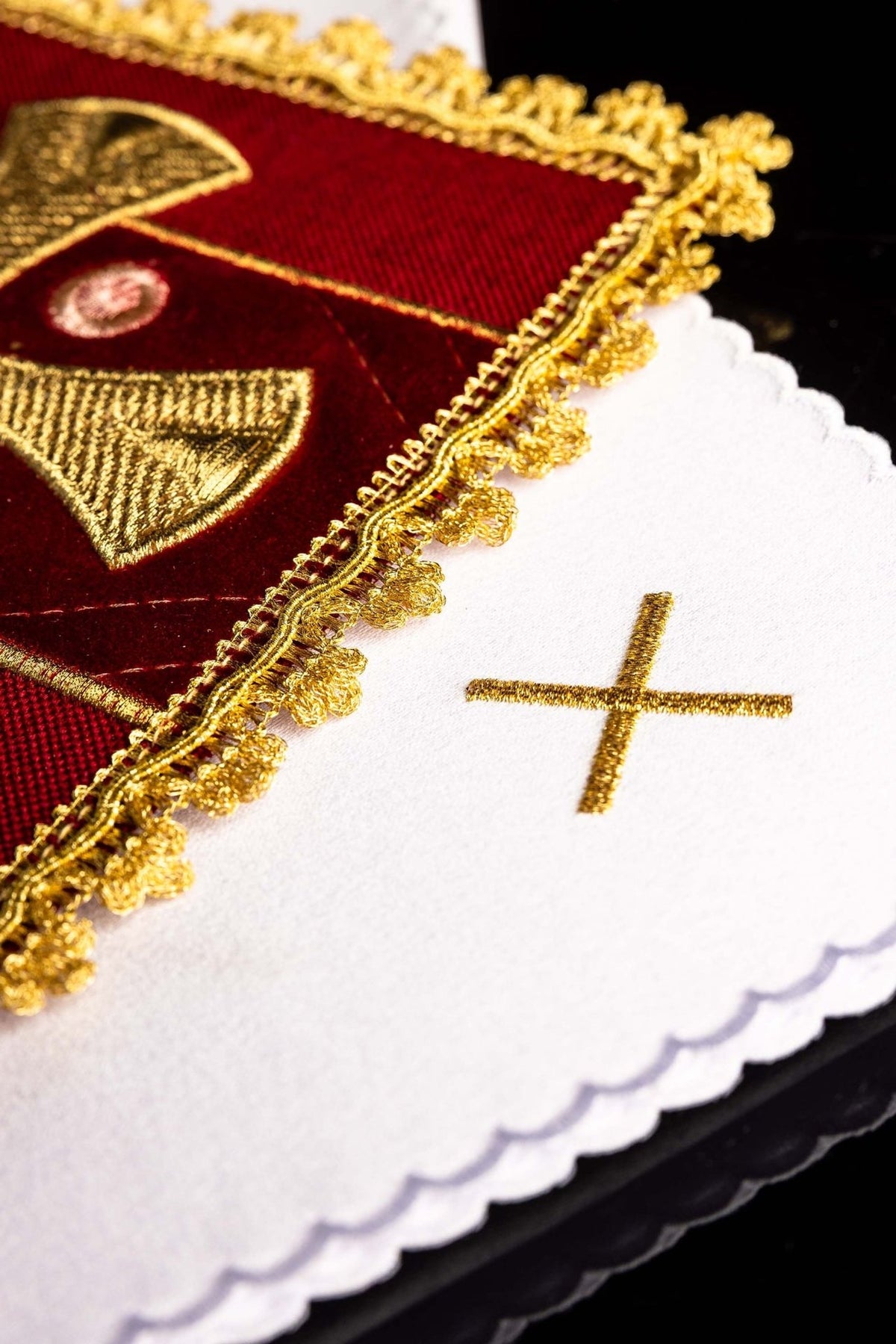 Red velvet corporal detail with gold embroidery and scalloped white altar linen