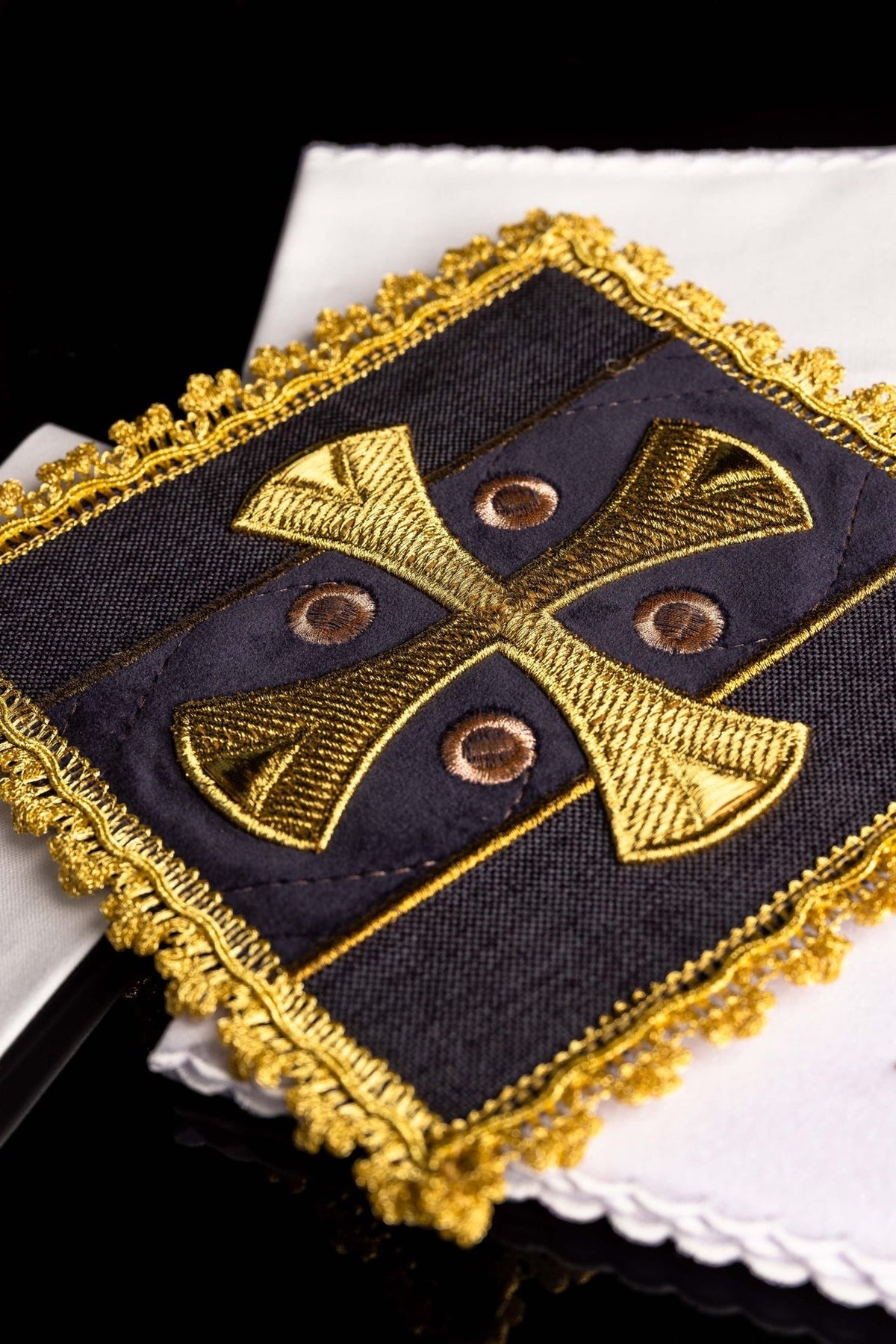 Purple chalice pall detail with embroidered gold cross, four circular motifs and ornate gold edging