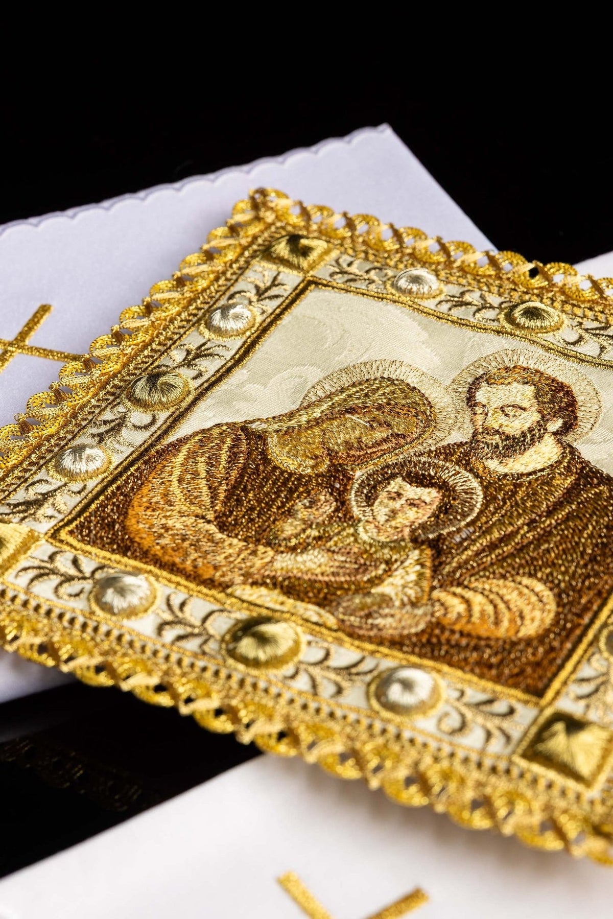 Altar linen set close-up showing embroidered Holy Family image and gold decorative border
