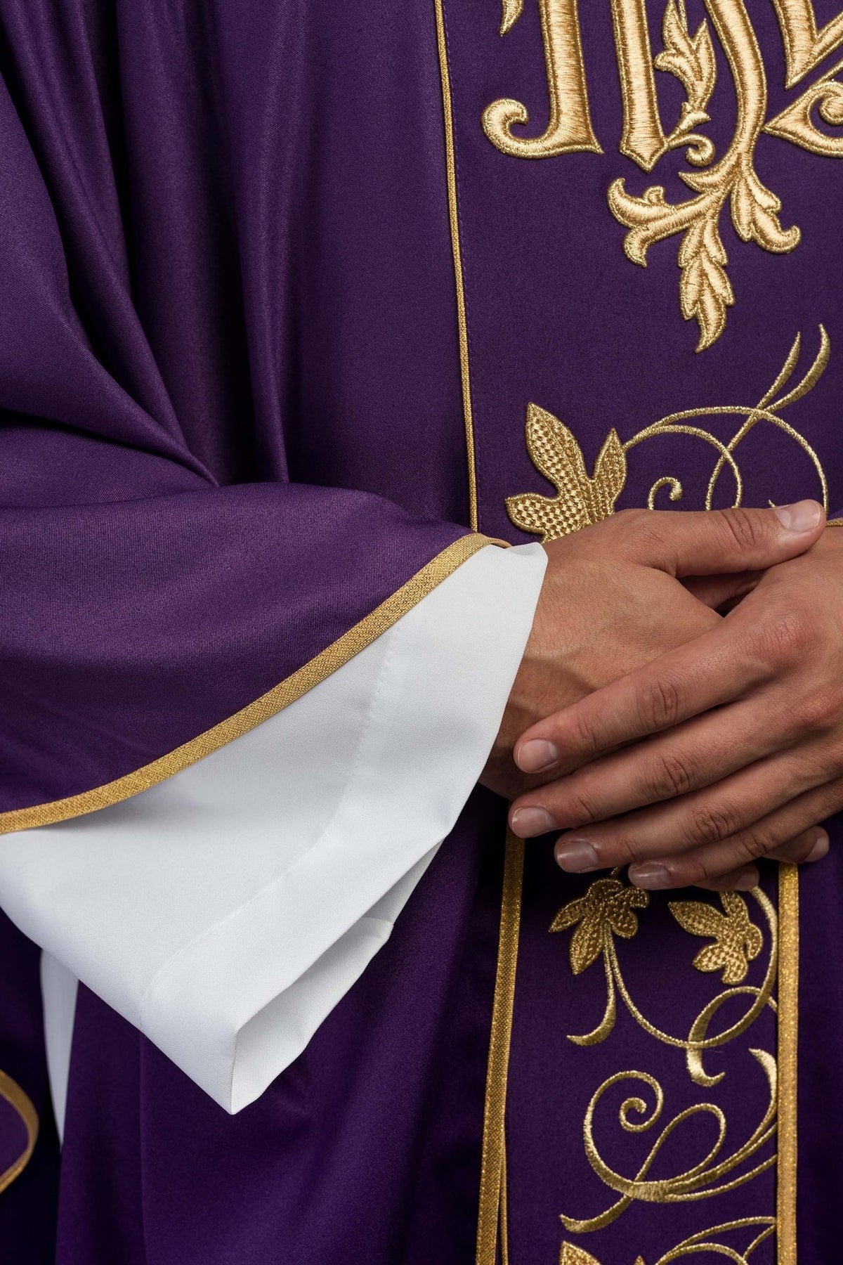 Purple chasuble, close-up showing gold floral embroidery and edged sleeve