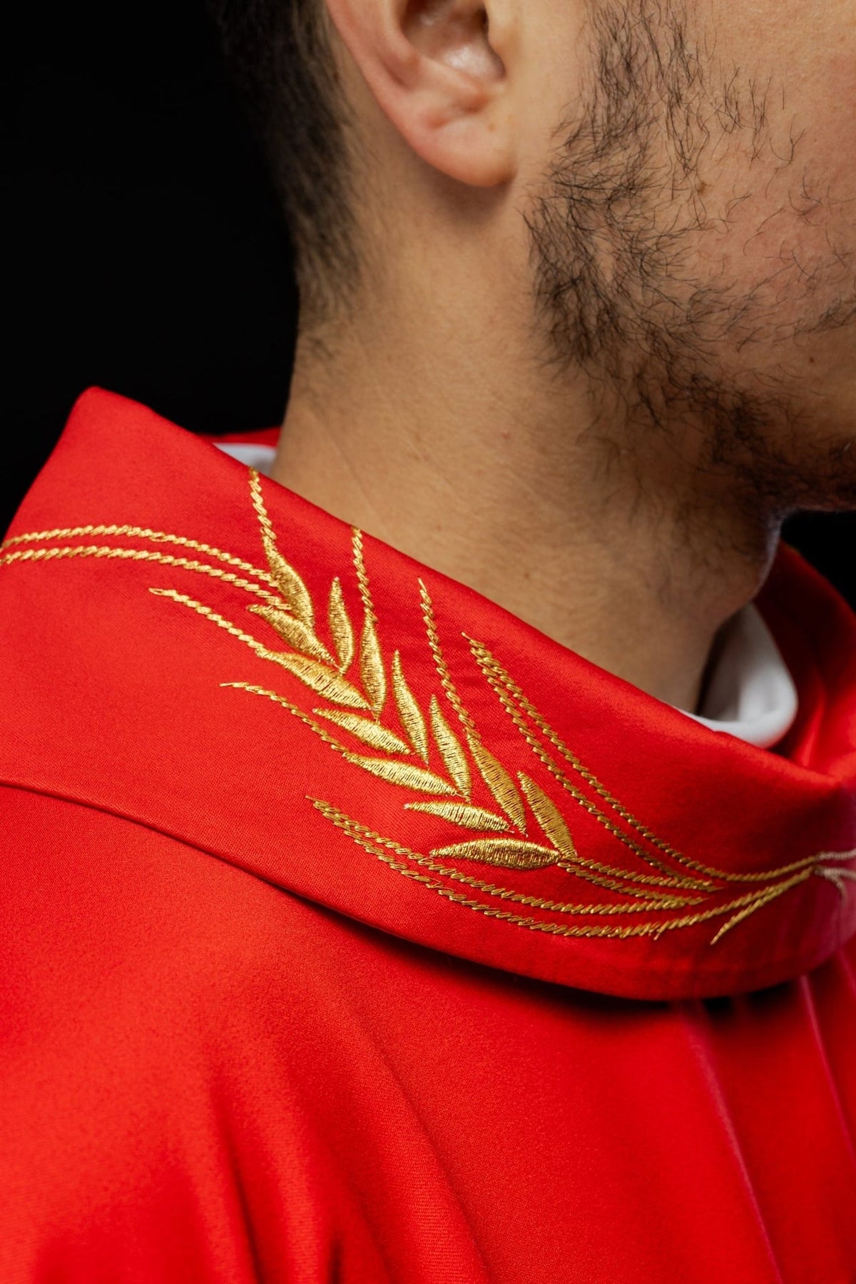 Red chasuble detail showing red satin fabric and gold trim
