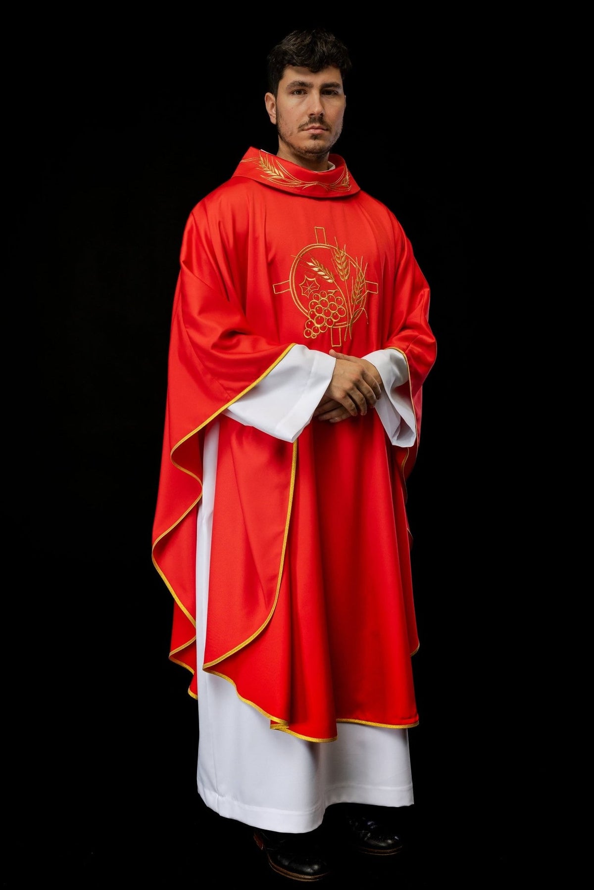 Red chasuble worn front view with gold trim and embroidered cross