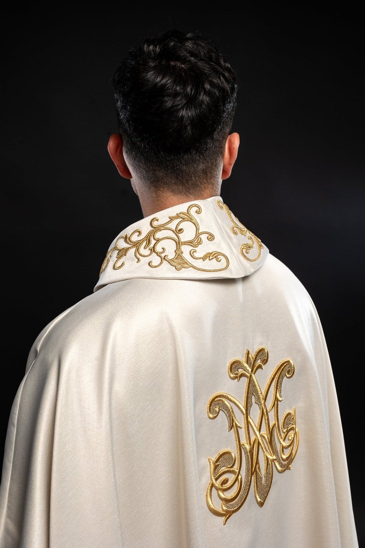 Liturgical chasuble back view with gold Marian monogram and ornamental collar embroidery