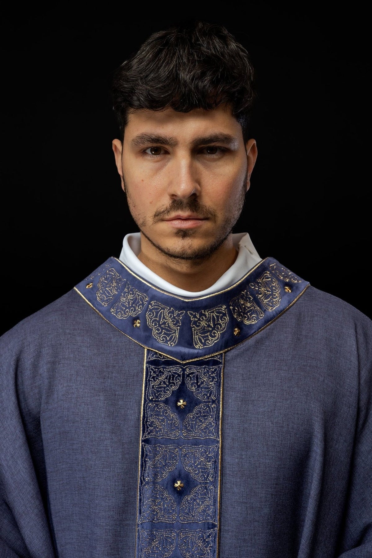 Purple chasuble worn from the front, showing the long embroidered orphrey and gold fringe