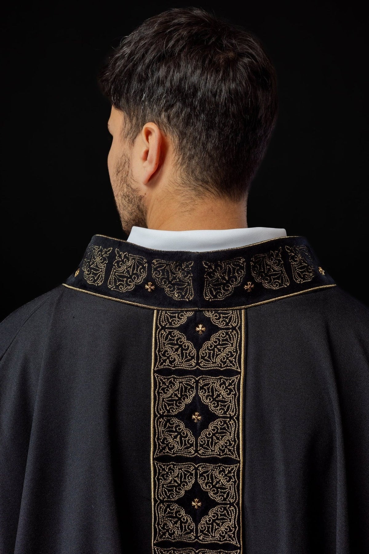 Black chasuble back close-up with gold embroidered collar and orphrey