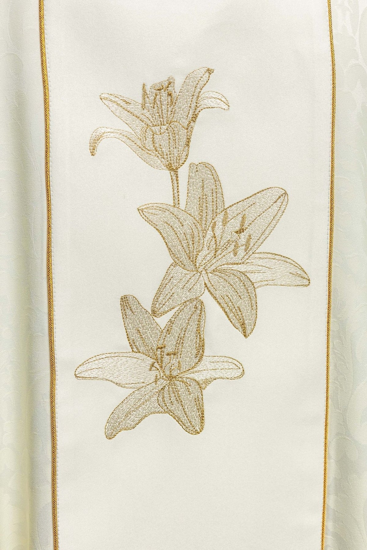 Chasuble close-up of three embroidered gold lilies on the ivory front panel
