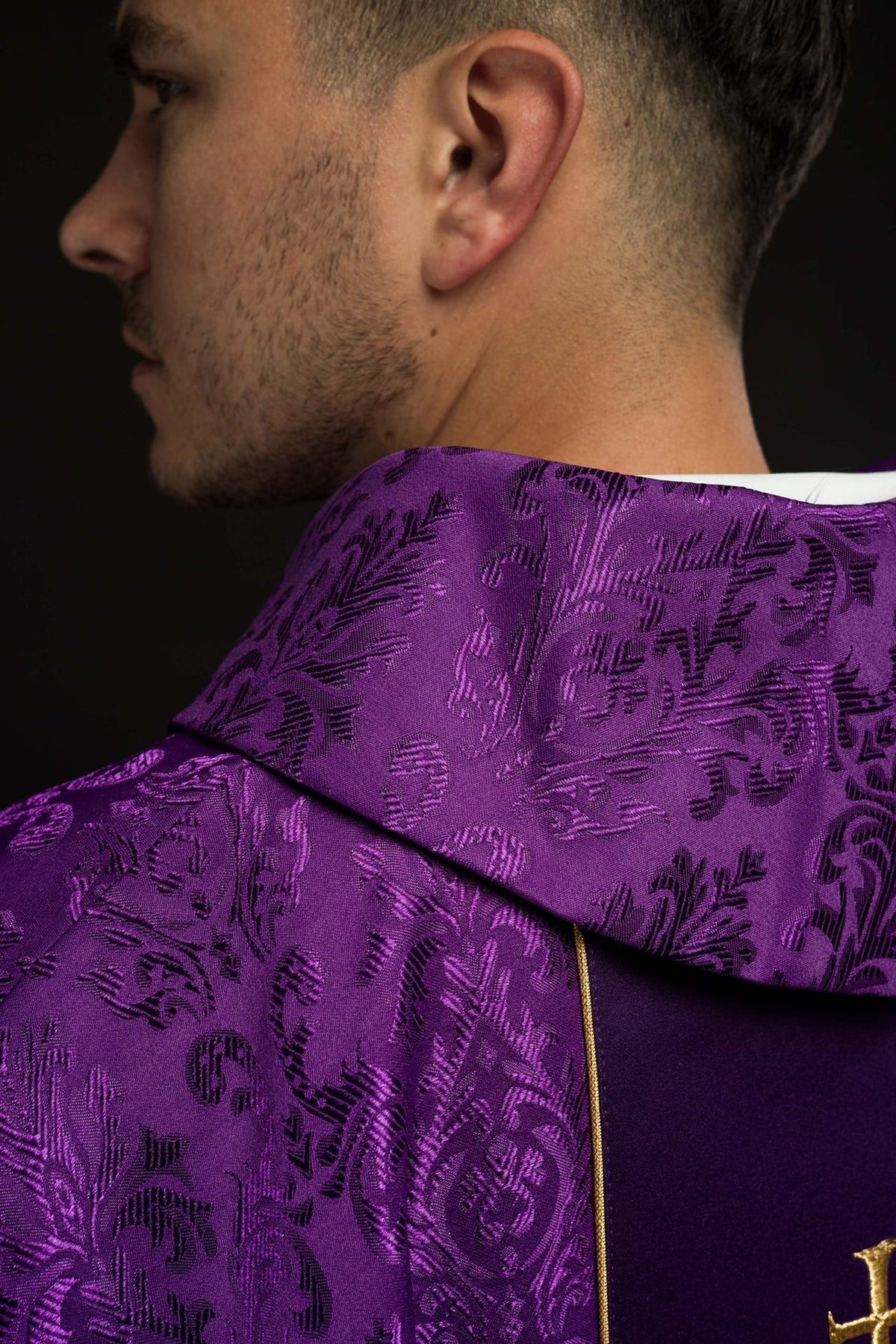 Purple chasuble close-up showing patterned satin fabric and stand-up collar