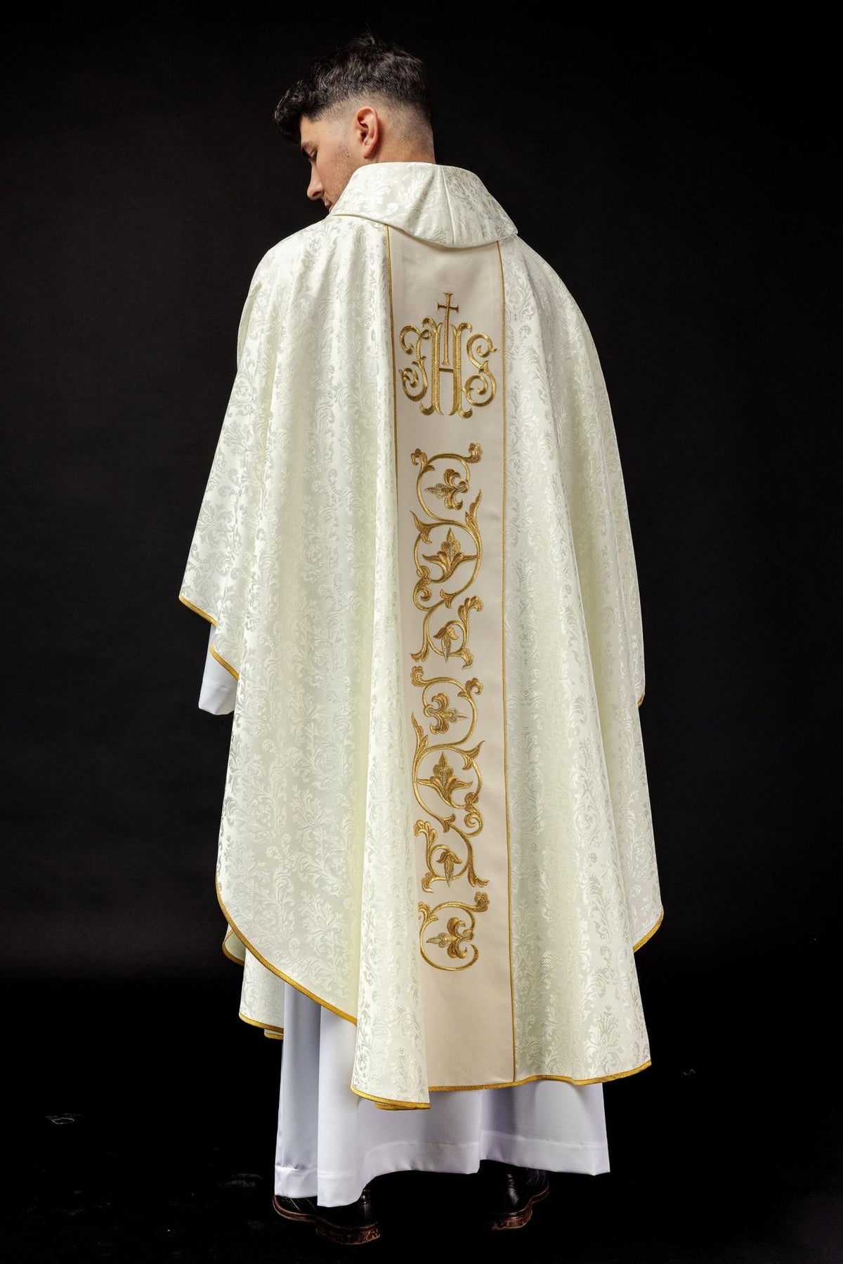 Ecru chasuble back view showing the full gold IHS orphrey and floral embroidery