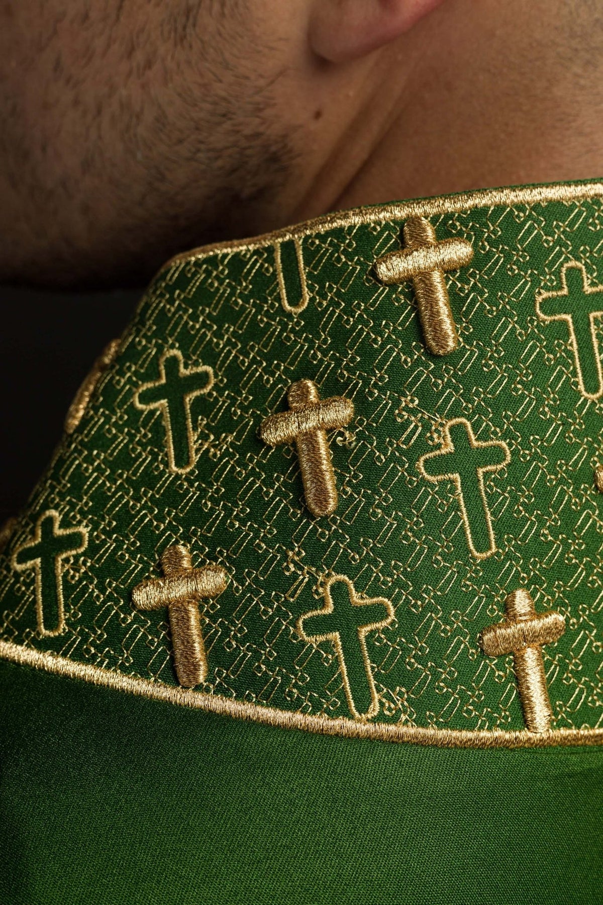Green chasuble collar close-up with gold cross embroidery