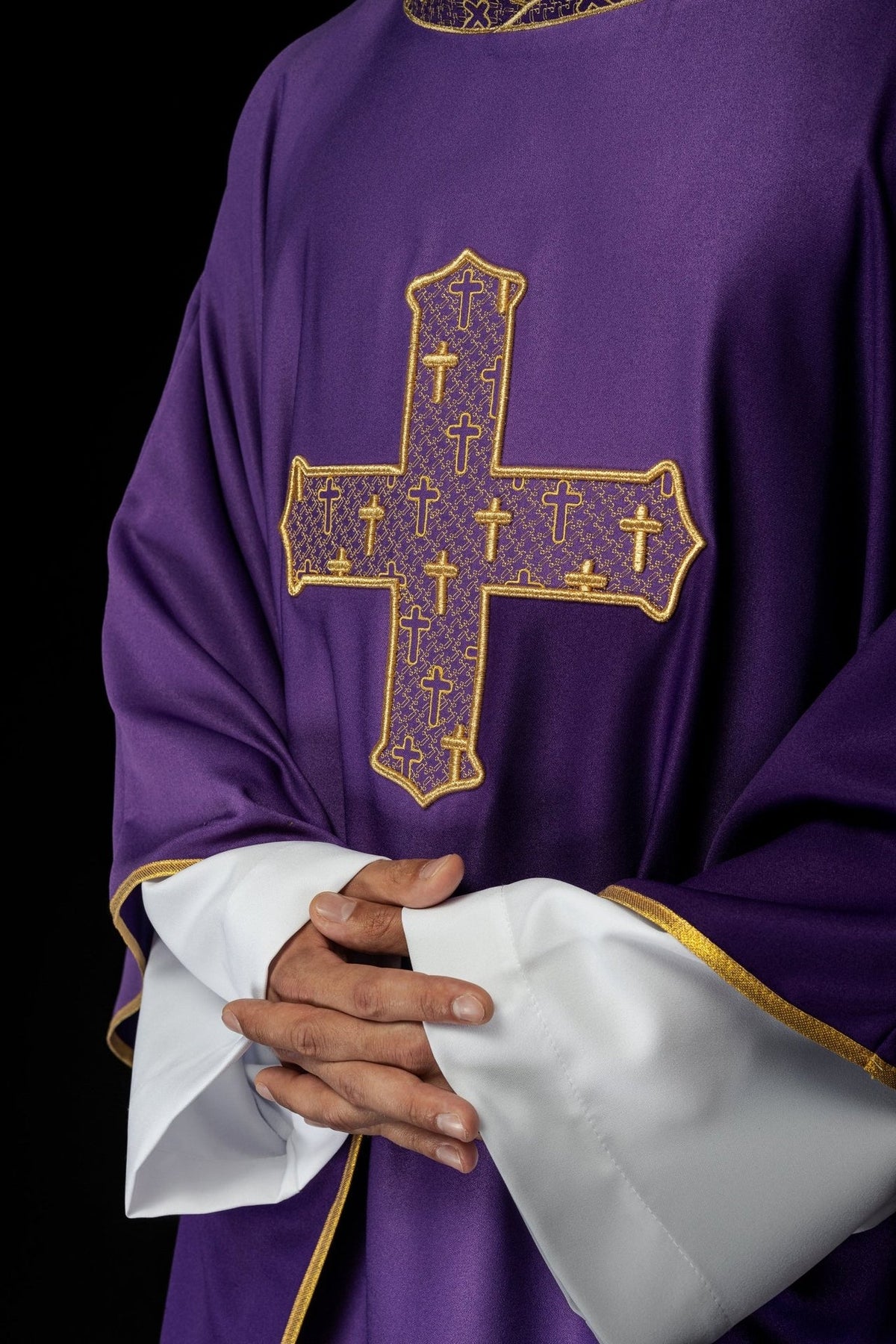 Purple chasuble close-up showing richly embroidered gold cross