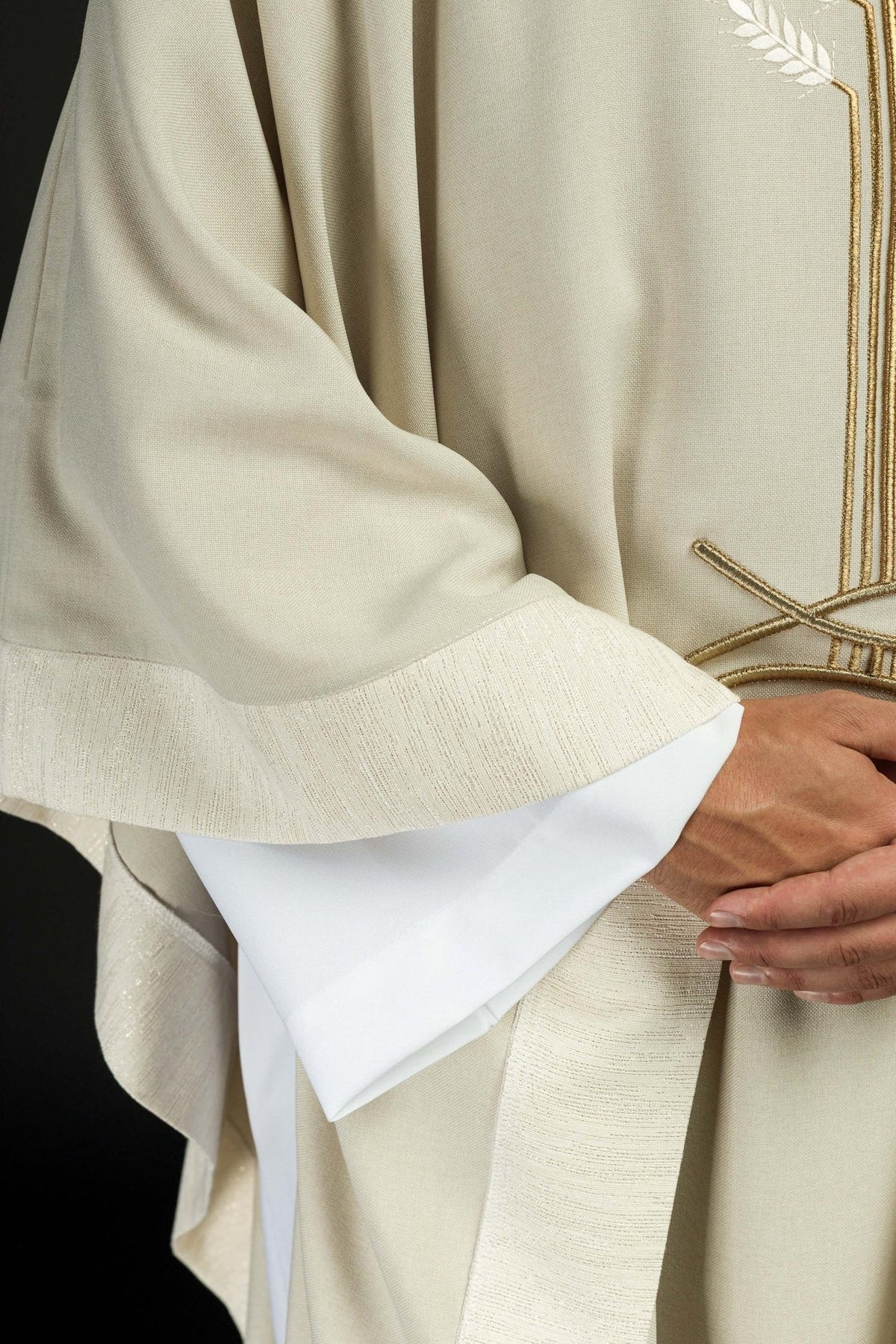 Ecru chasuble sleeve close-up with textured cuff embroidery