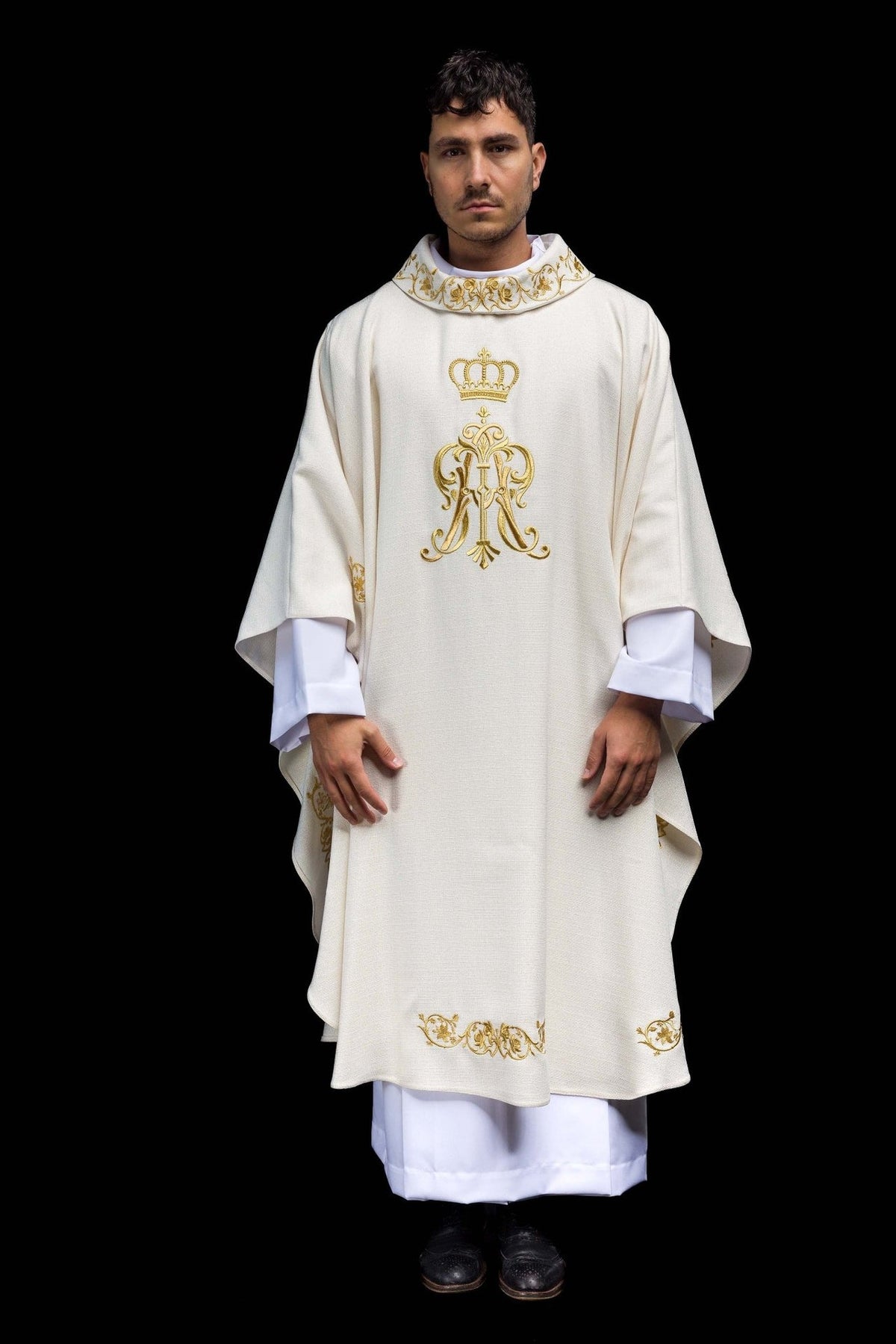 Liturgical chasuble front view showing white fabric, gold crown and Marian monogram