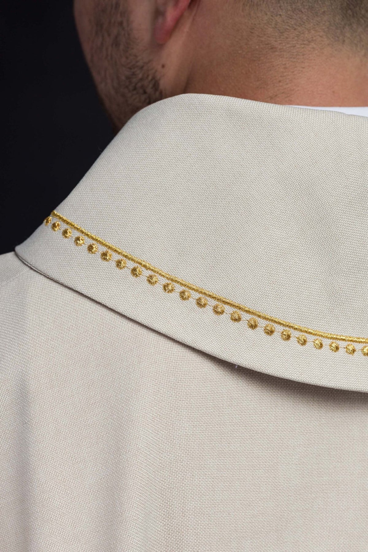 Ecru chasuble sleeve close-up with finished trim