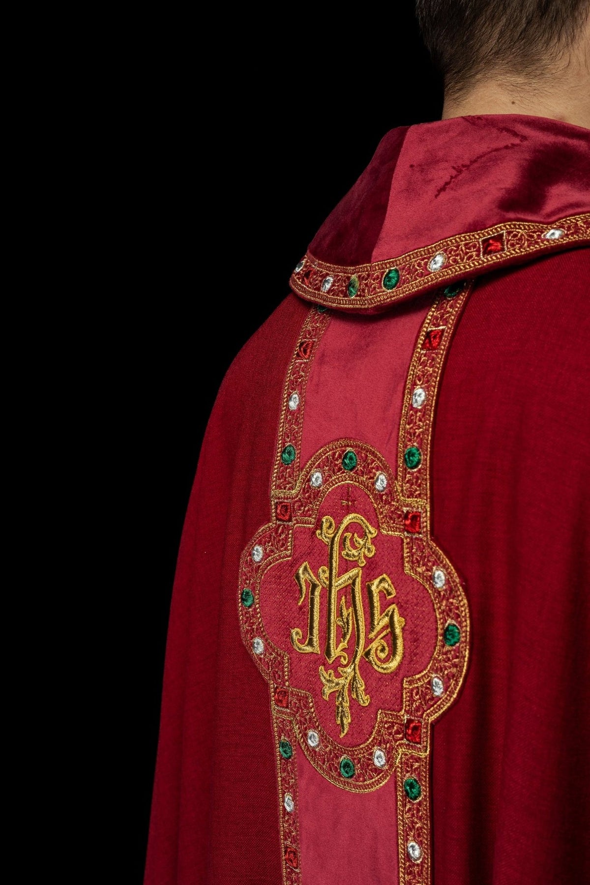 Red chasuble back three-quarter view with embroidered IHS orphrey
