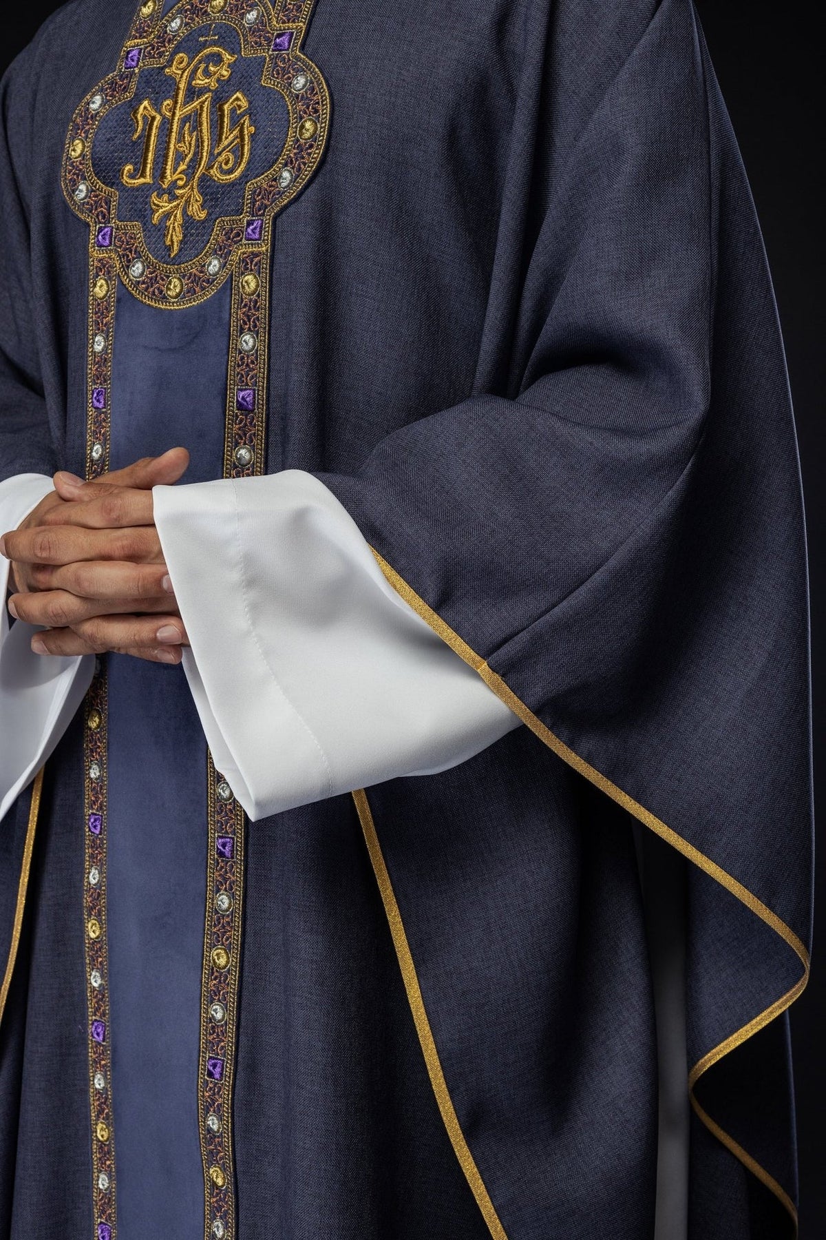Purple chasuble side close-up showing wide sleeve, white cuff and gold trim