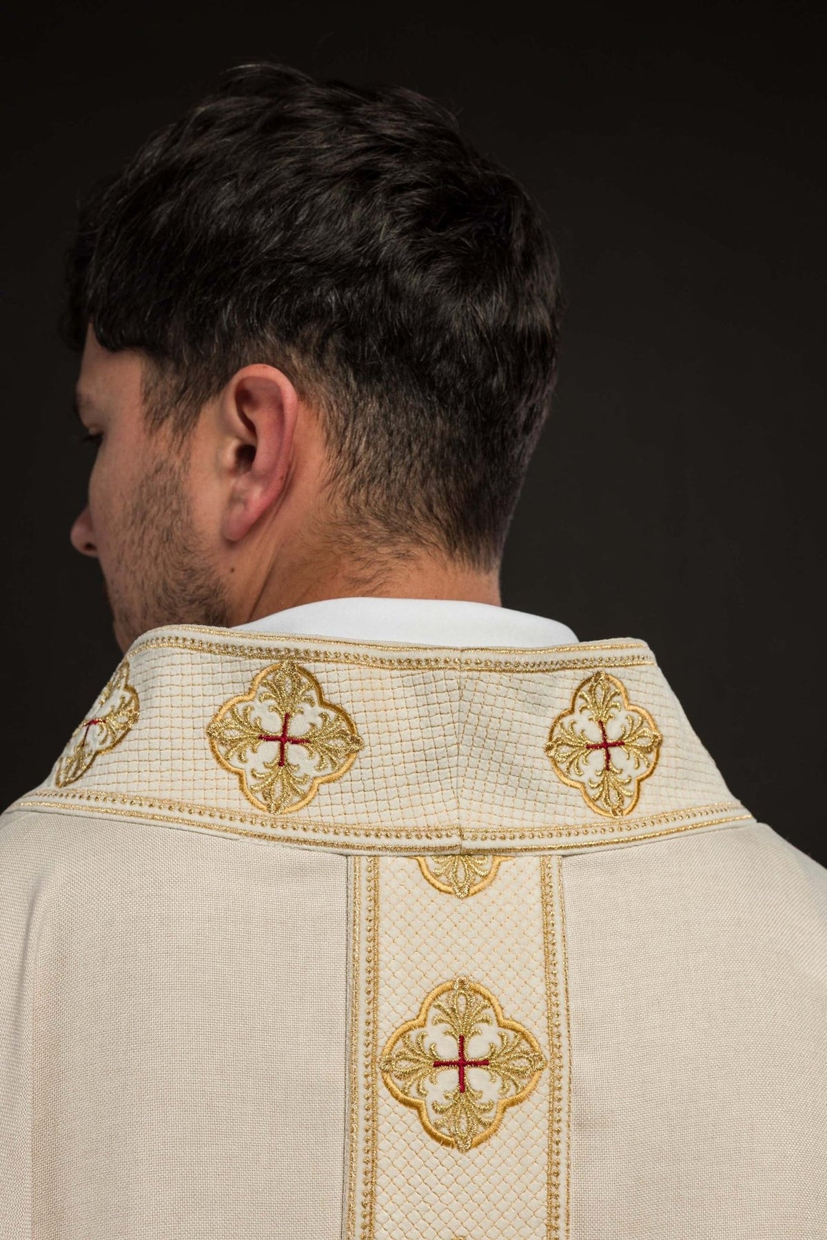 Ecru chasuble orphrey close-up with gold cross embroidery and fringe