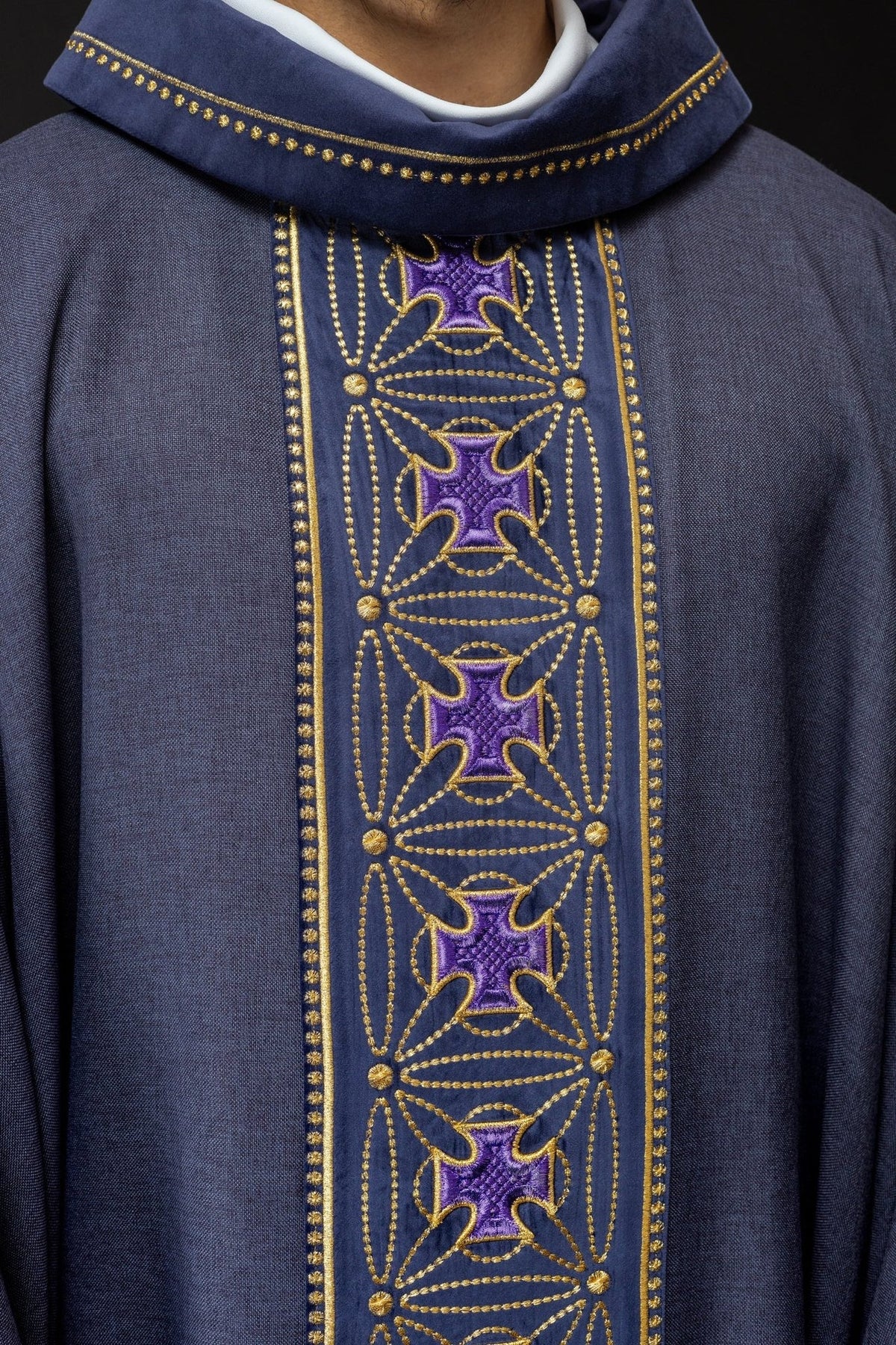 Purple chasuble close-up showing embroidered purple crosses and gold trim