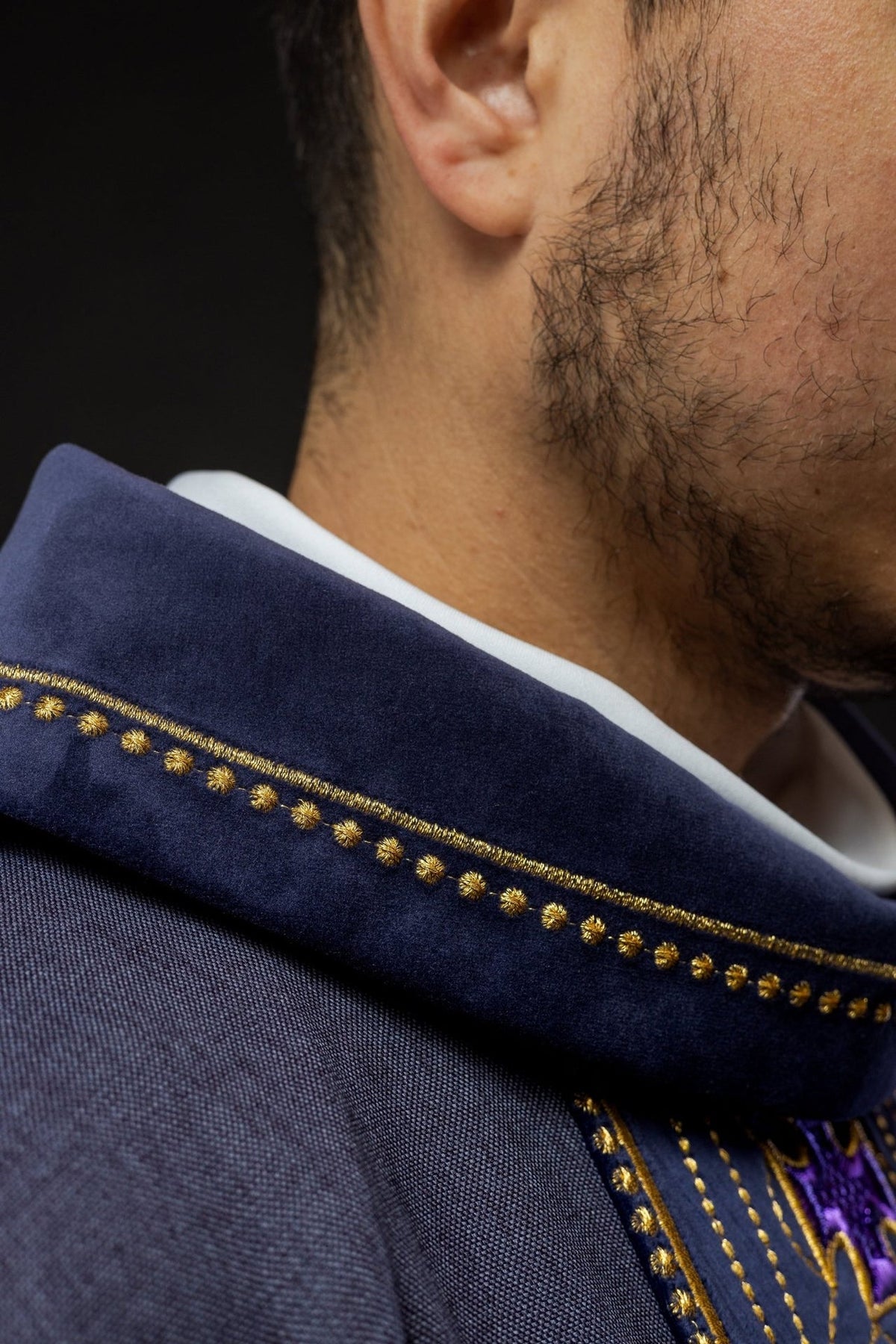 Purple chasuble sleeve detail with gold trim and embroidered orphrey