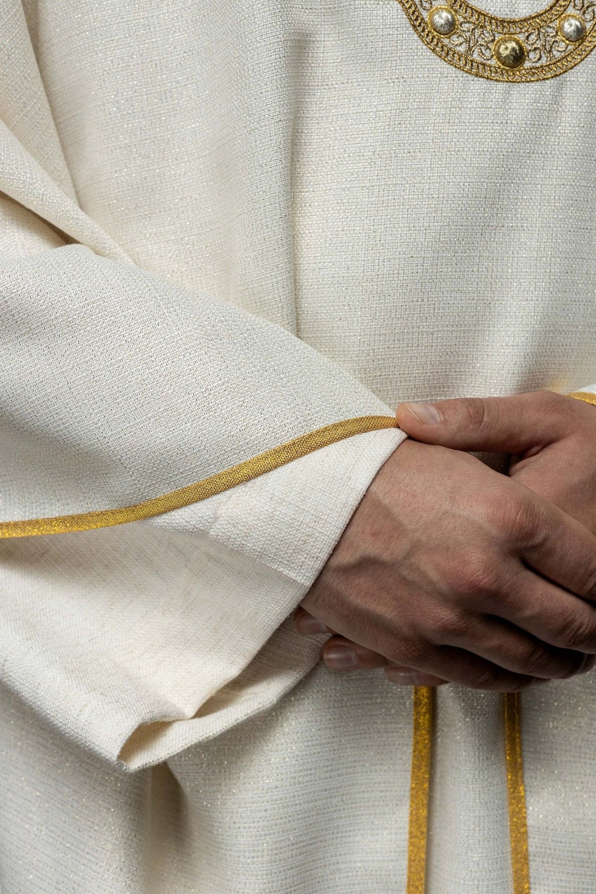 Liturgical chasuble detail showing white fabric, gold collar galloon and Marian embroidery